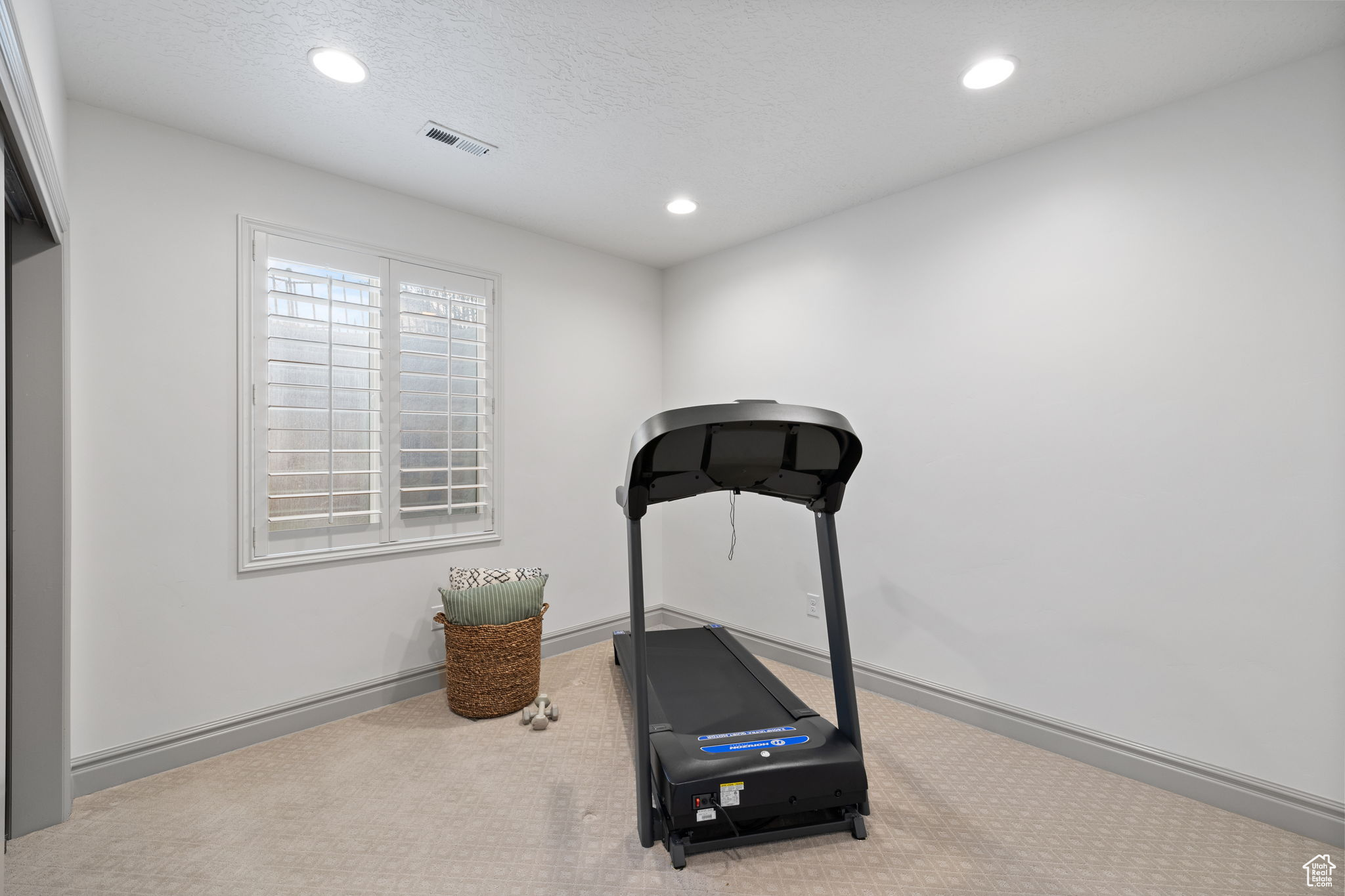 Exercise room featuring a textured ceiling and carpet floors