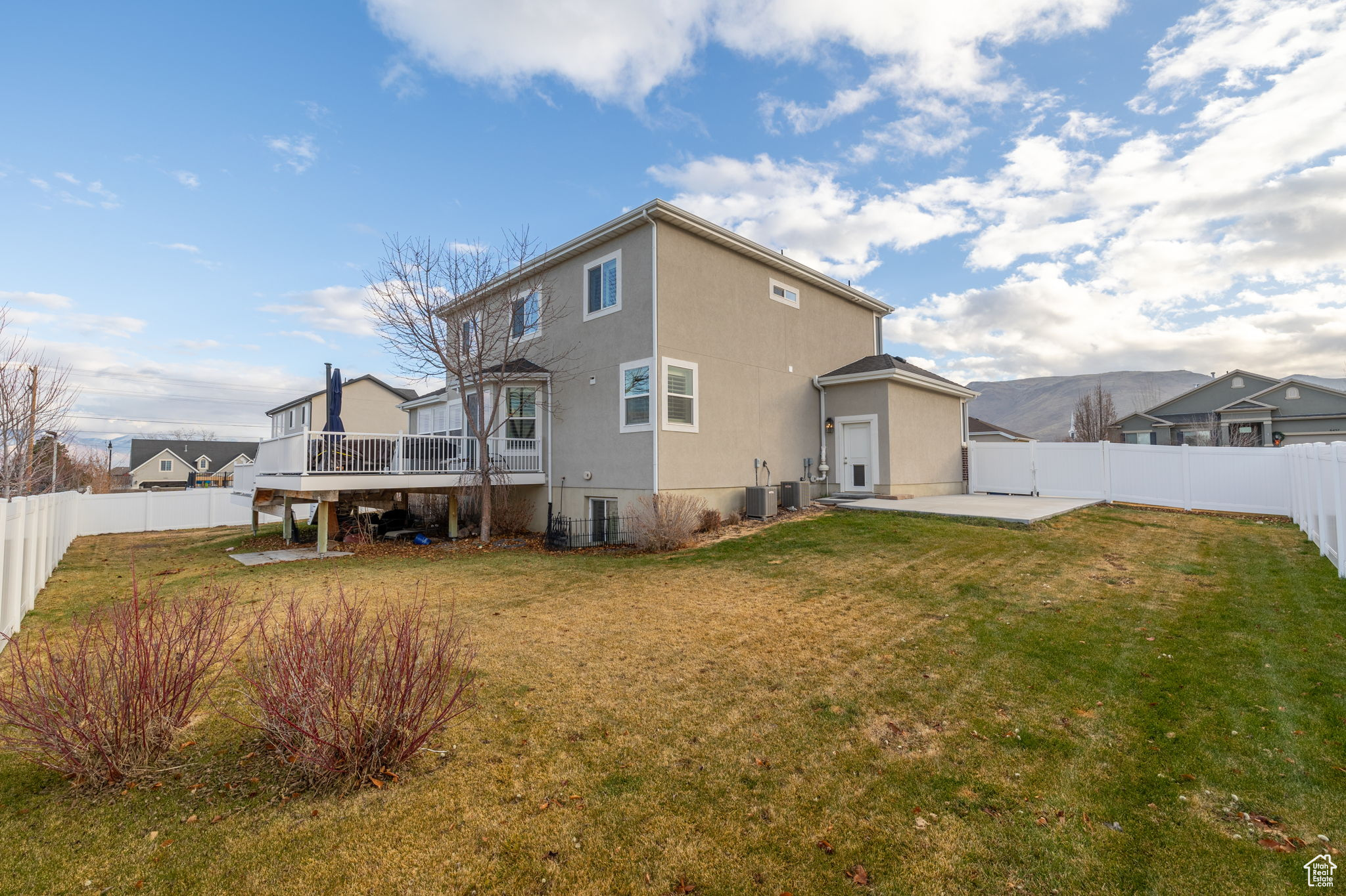 Back of house with a lawn, a deck, a patio, and central air condition unit