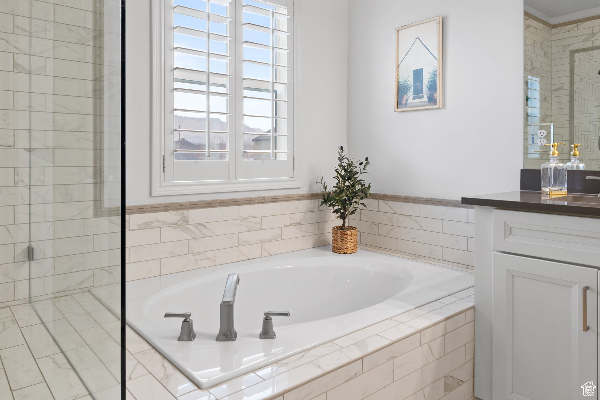 Bathroom featuring vanity and shower with separate bathtub