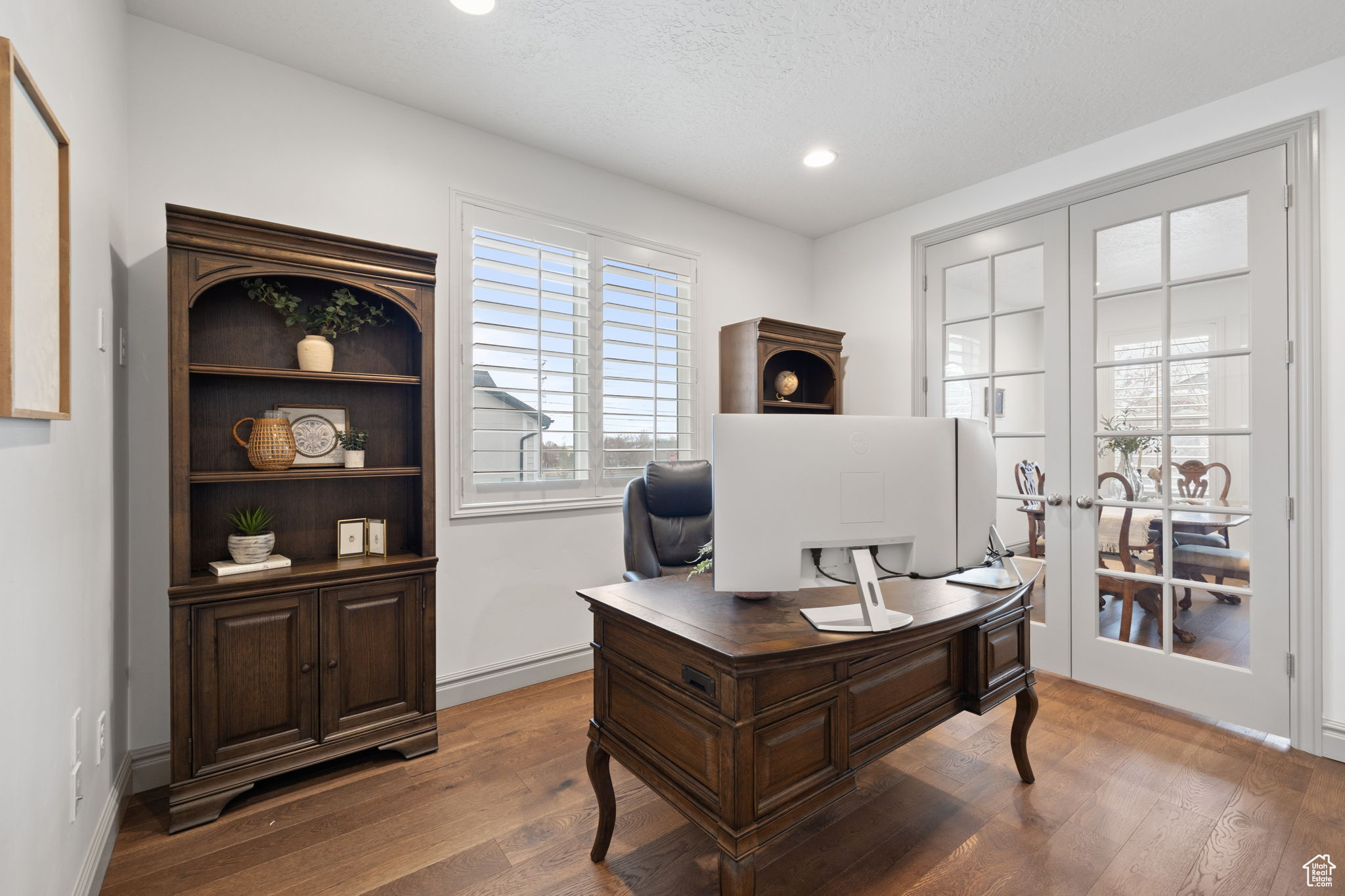 Home office featuring hardwood / wood-style flooring, a textured ceiling, and french doors