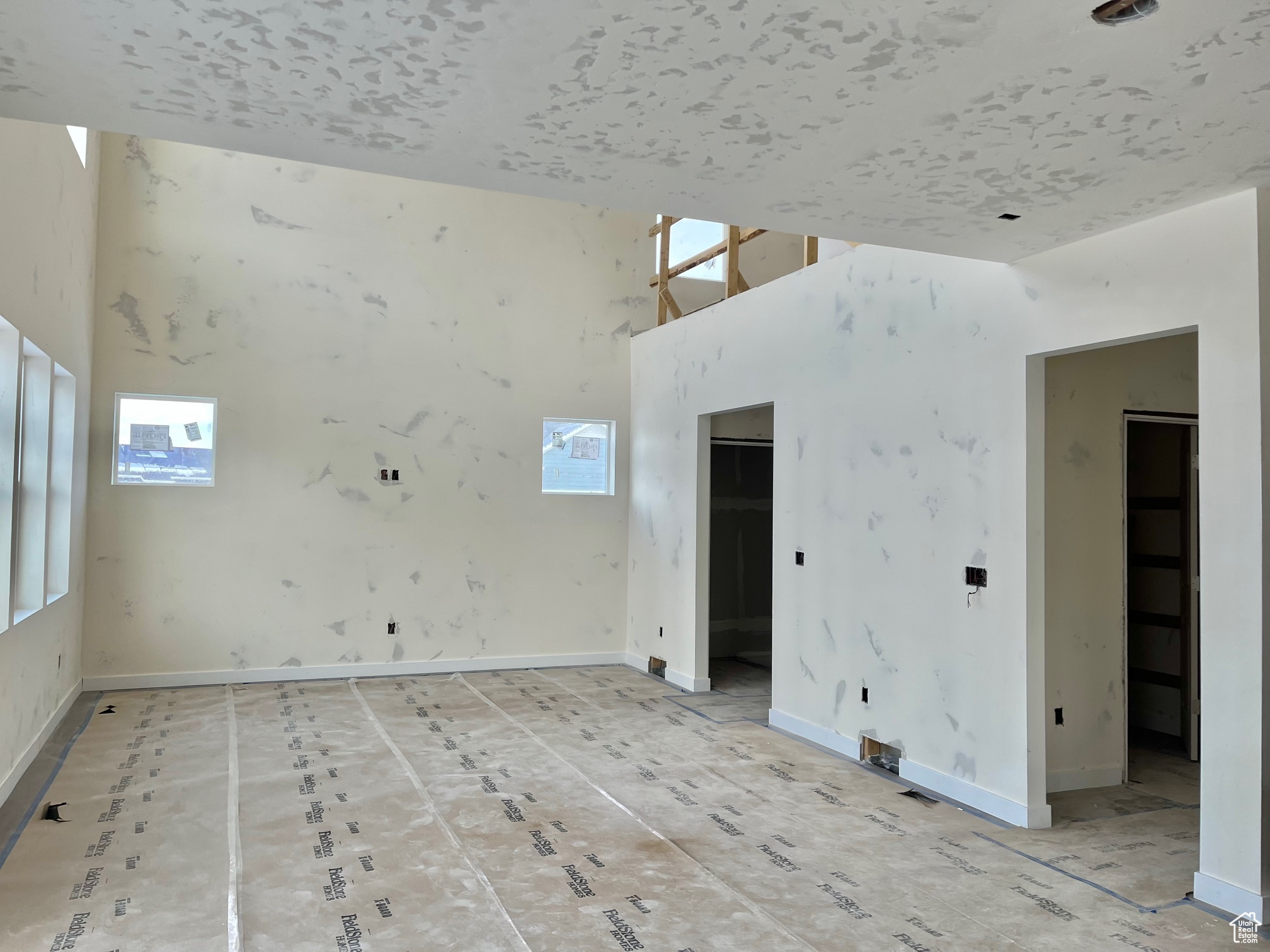 Empty room featuring a towering ceiling