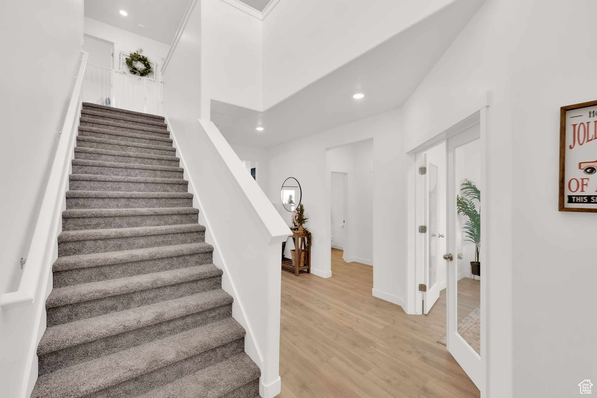 Stairway with wood-type flooring and a high ceiling