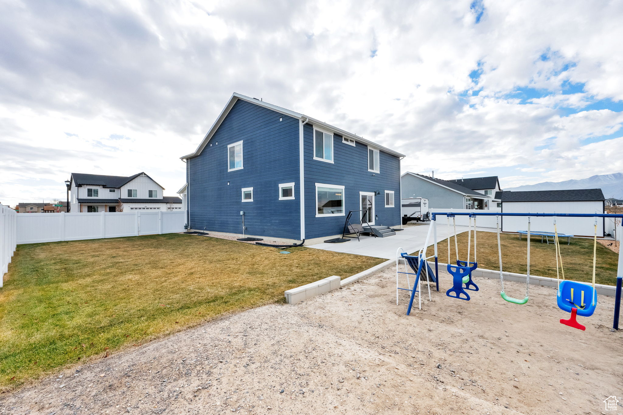 Rear view of property featuring a lawn, a playground, and a patio