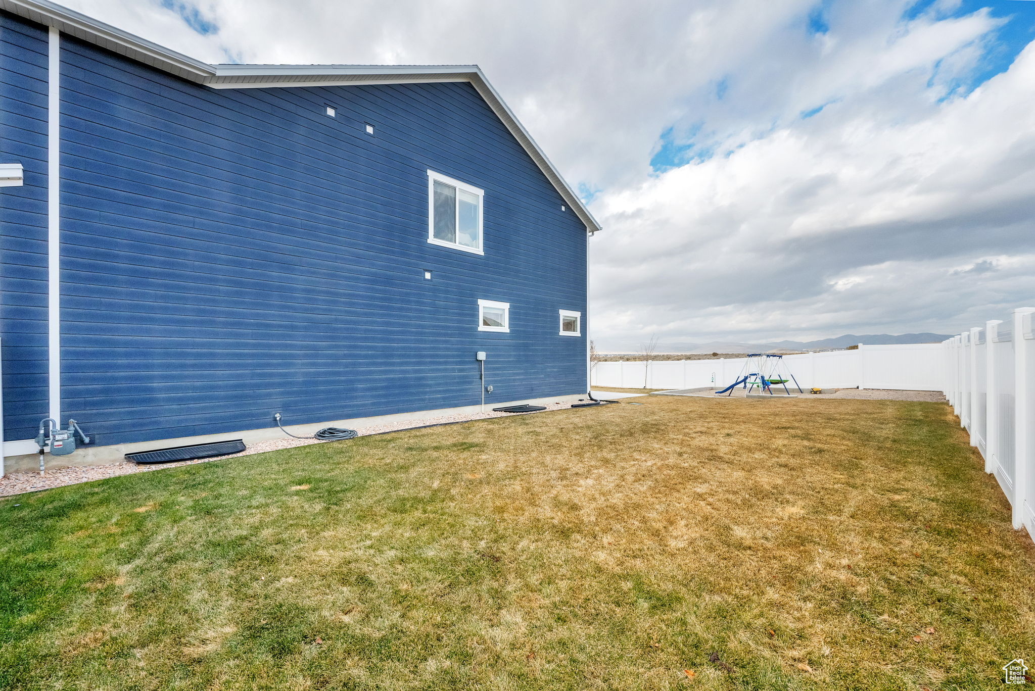 View of home's exterior with a yard and a playground