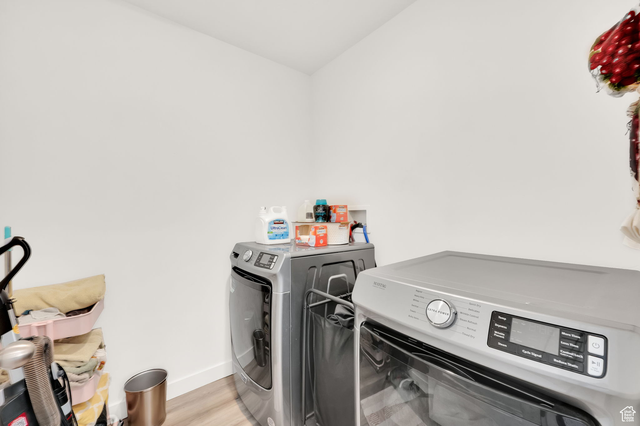 Washroom with separate washer and dryer and light hardwood / wood-style flooring