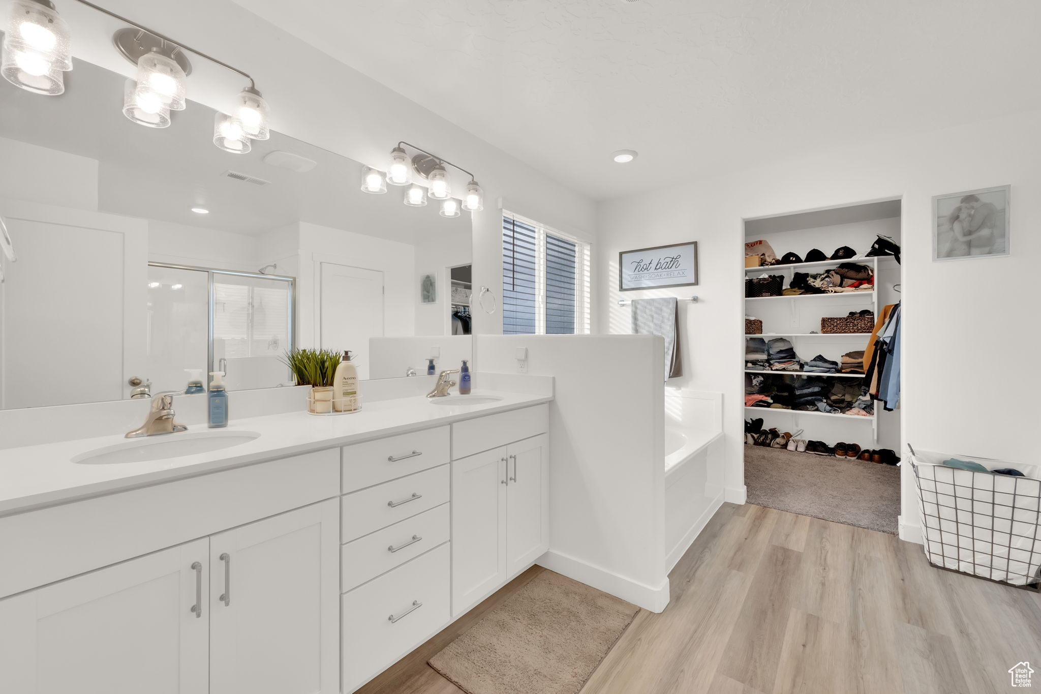 Bathroom featuring vanity, hardwood / wood-style flooring, and walk in shower