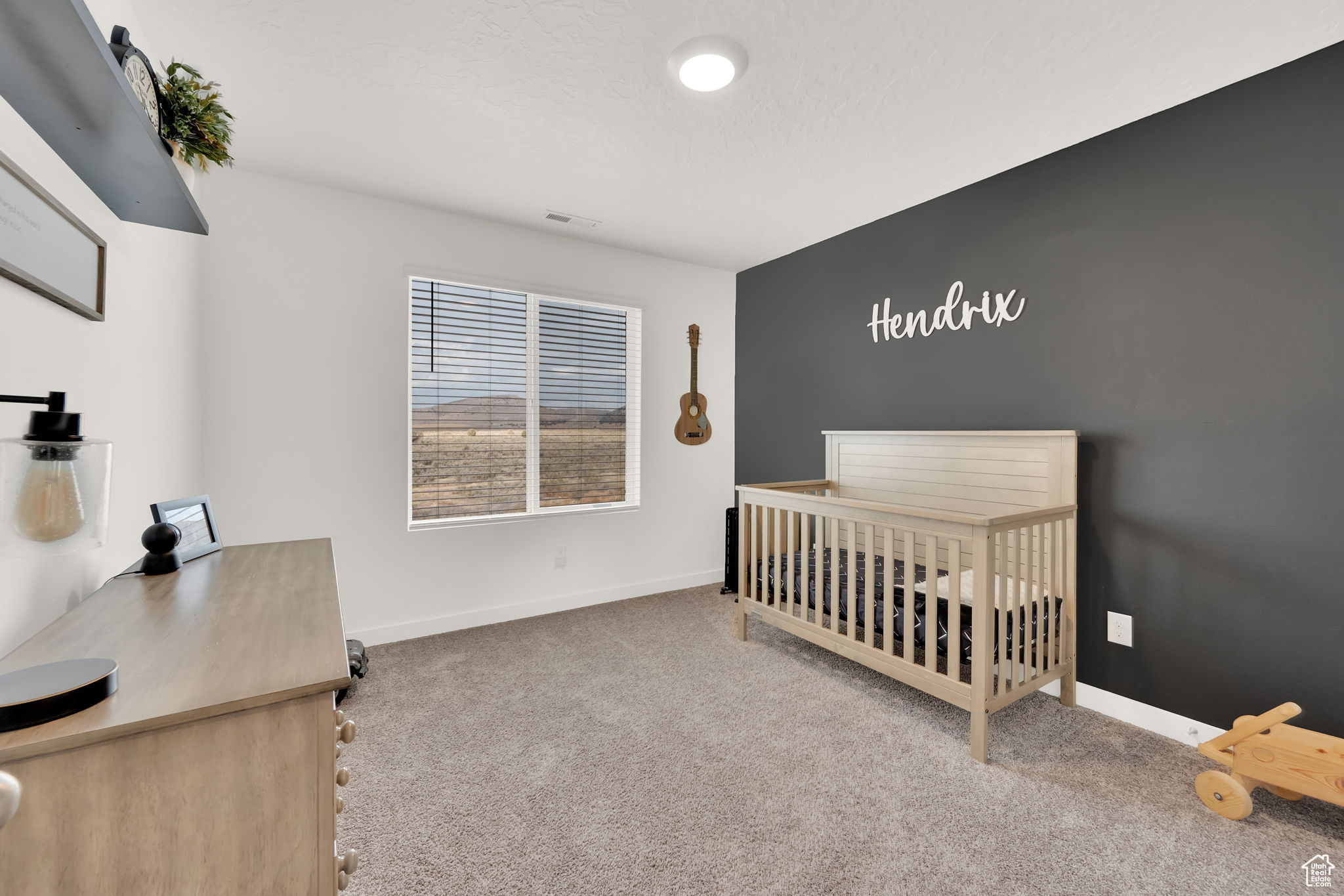 Bedroom featuring carpet and a nursery area