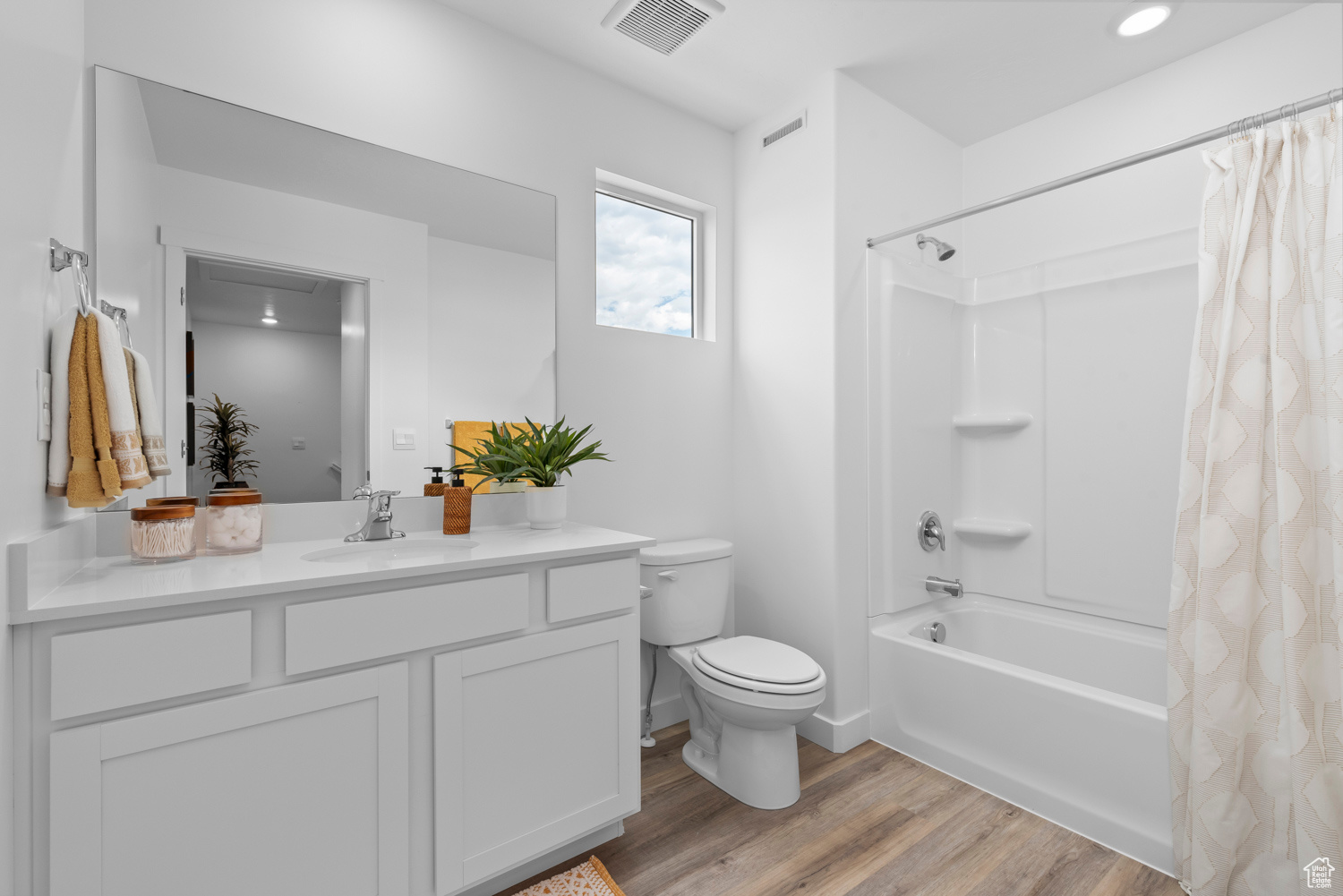 Full bathroom with shower / bath combination with curtain, toilet, wood-type flooring, and vanity