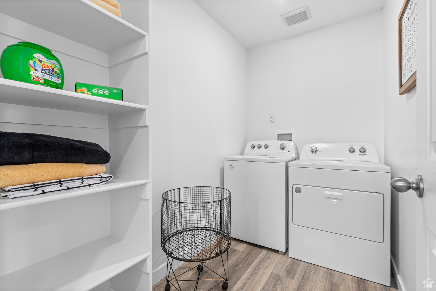 Laundry area with light hardwood / wood-style floors and washer and clothes dryer