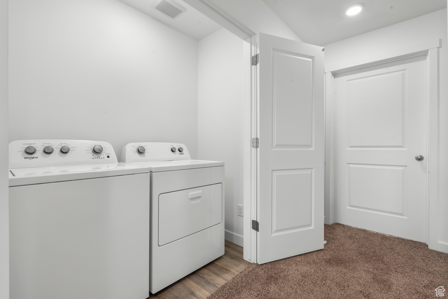 Laundry area featuring washer and clothes dryer and light colored carpet