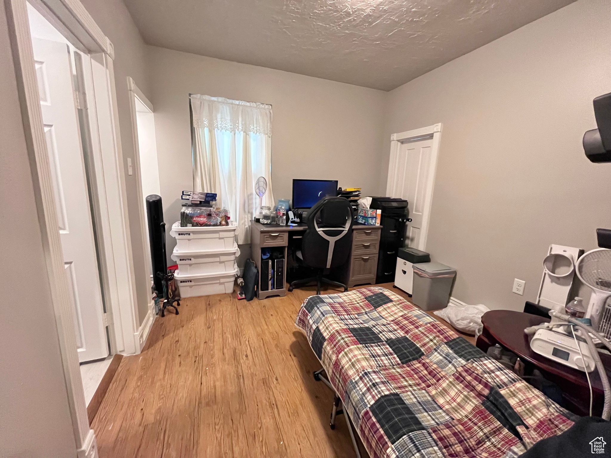 Bedroom featuring a textured ceiling and light hardwood / wood-style flooring