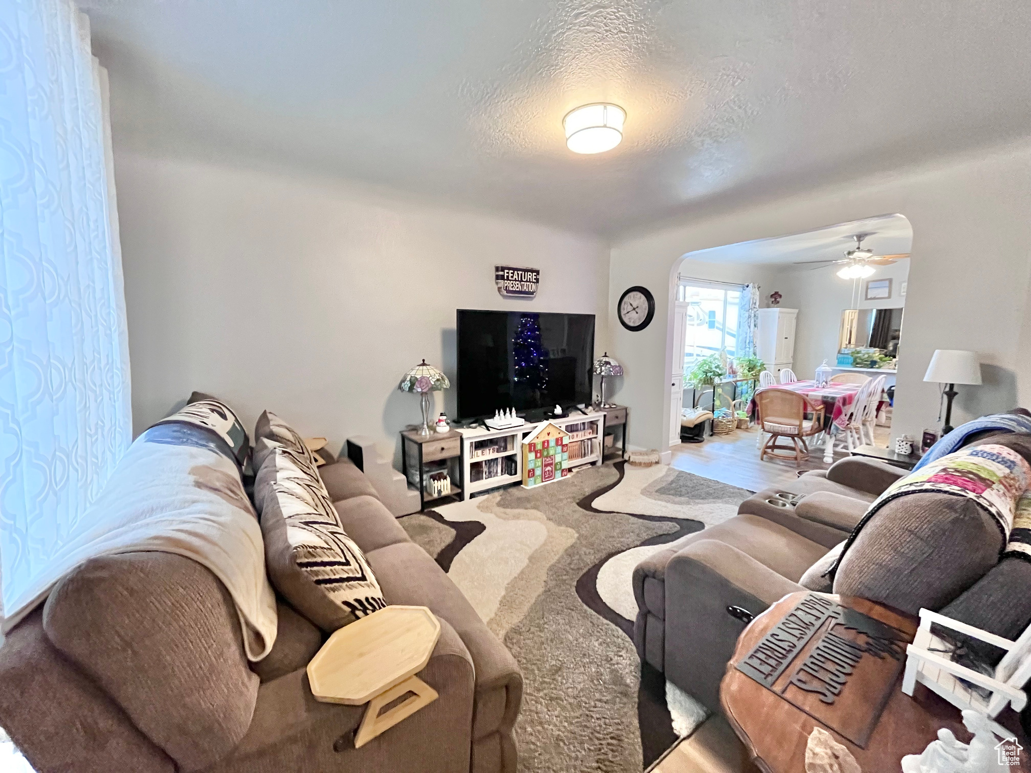 Living room featuring a textured ceiling and ceiling fan