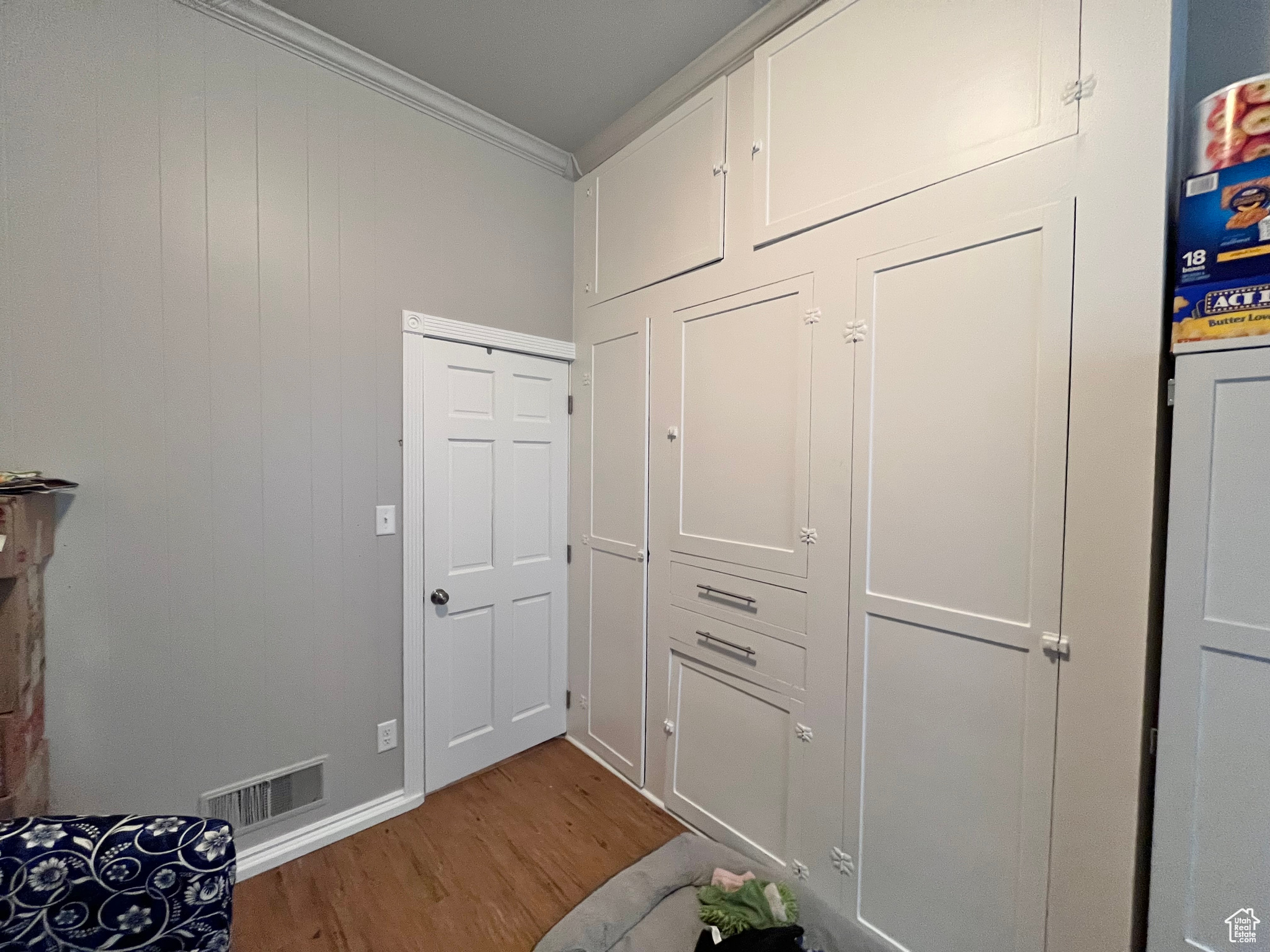 Interior space with hardwood / wood-style flooring and crown molding