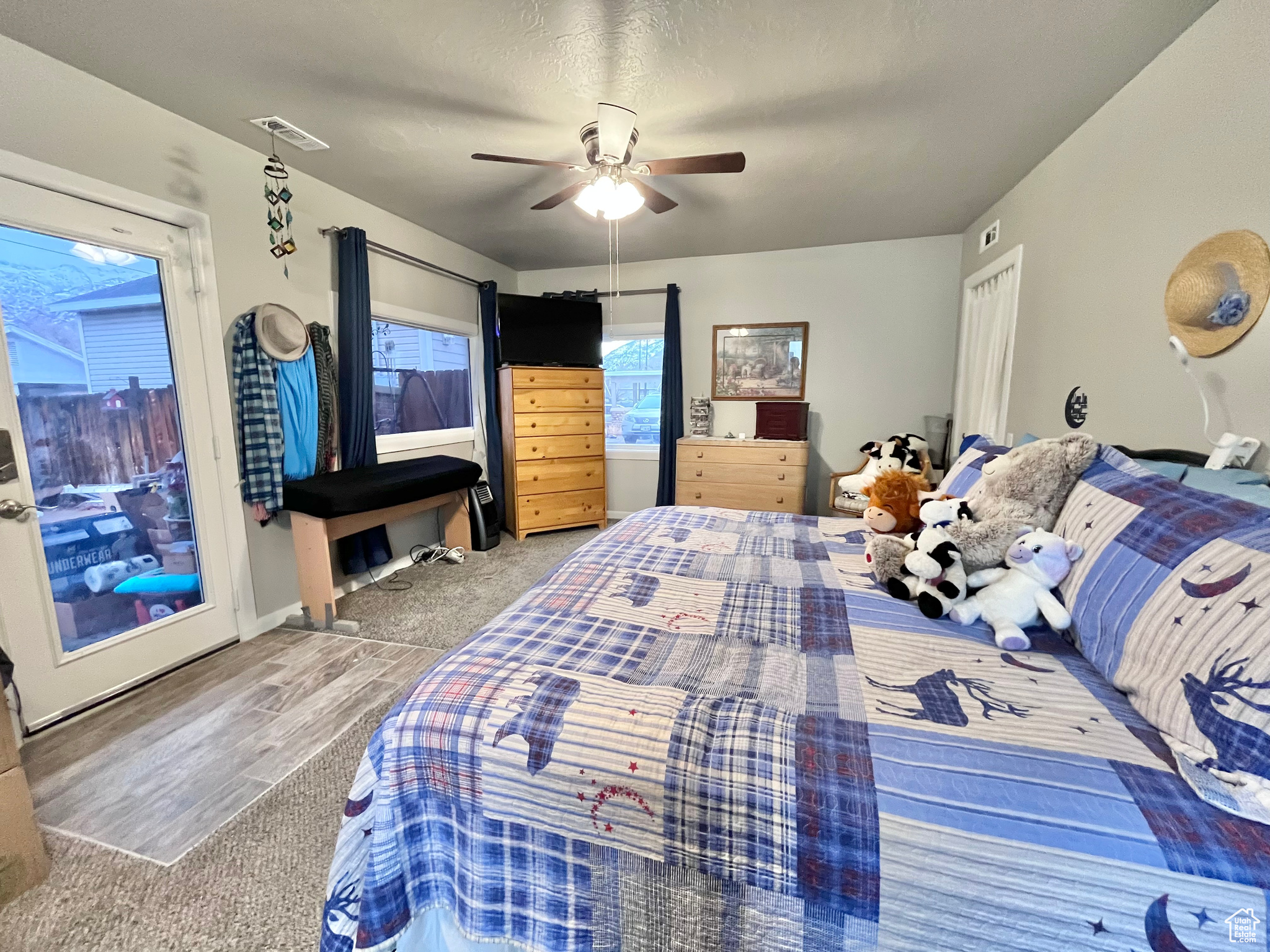 Carpeted bedroom featuring ceiling fan and a textured ceiling