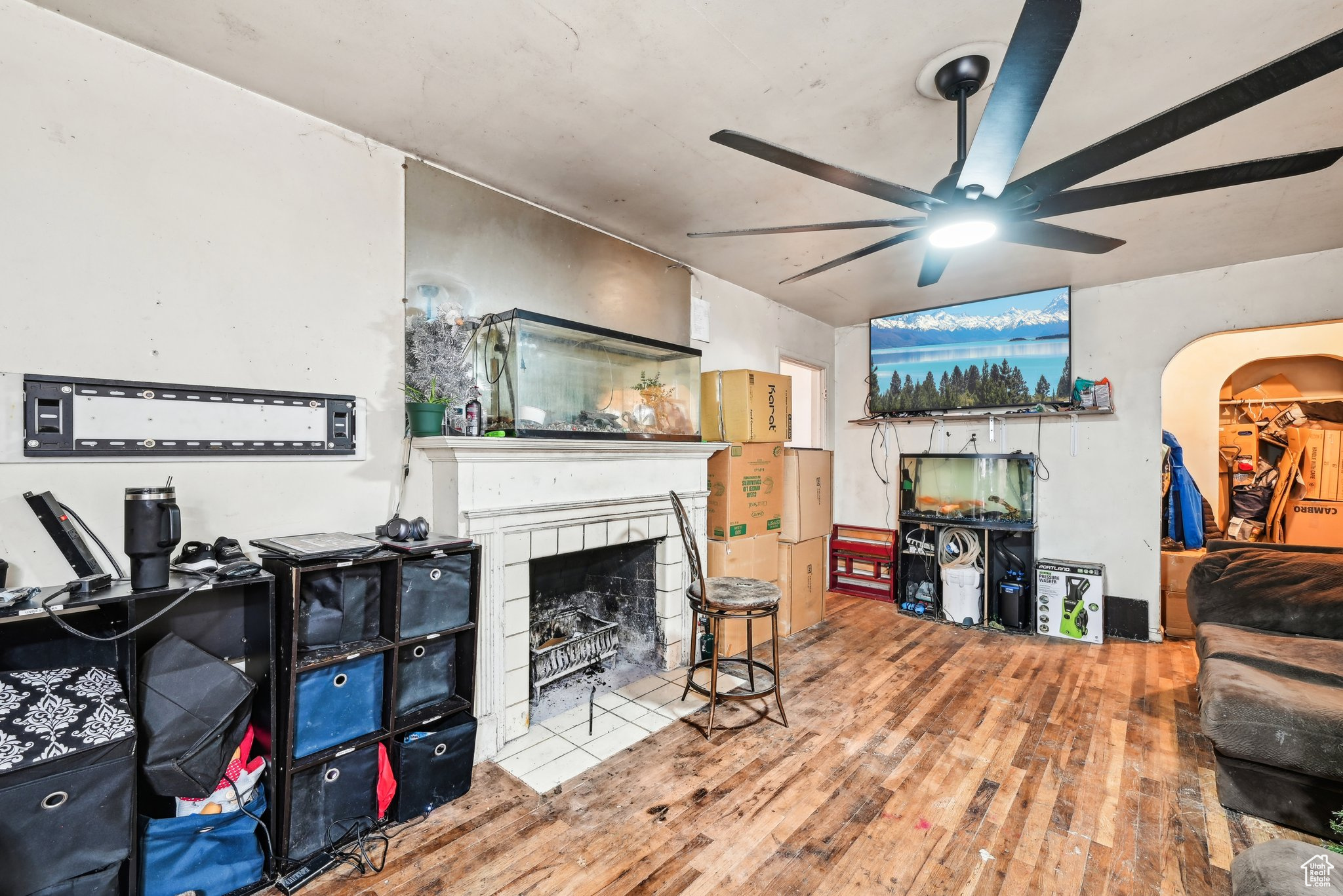 Living room with ceiling fan, a fireplace, and wood-type flooring