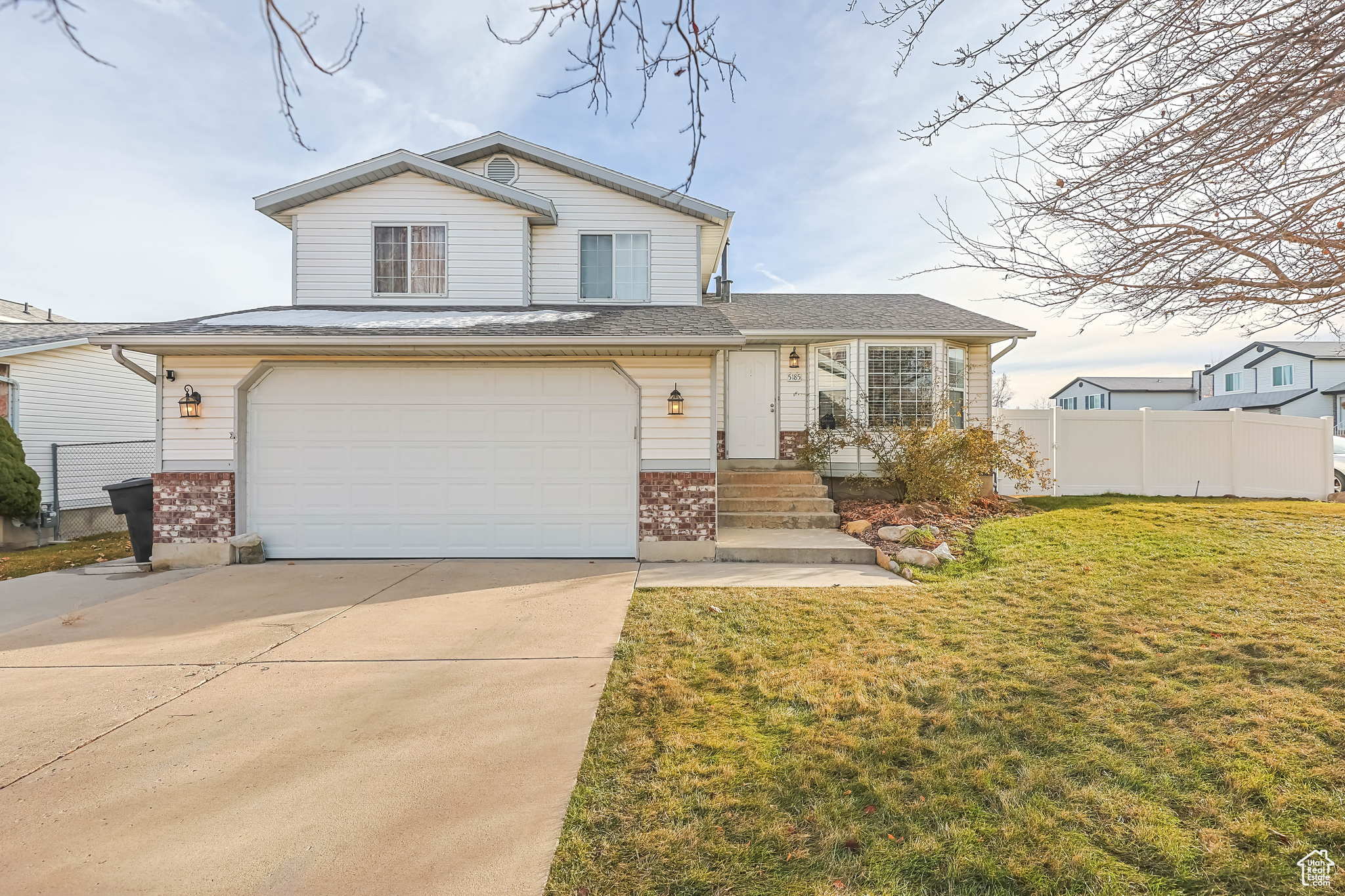 View of front of property with a front yard and a garage