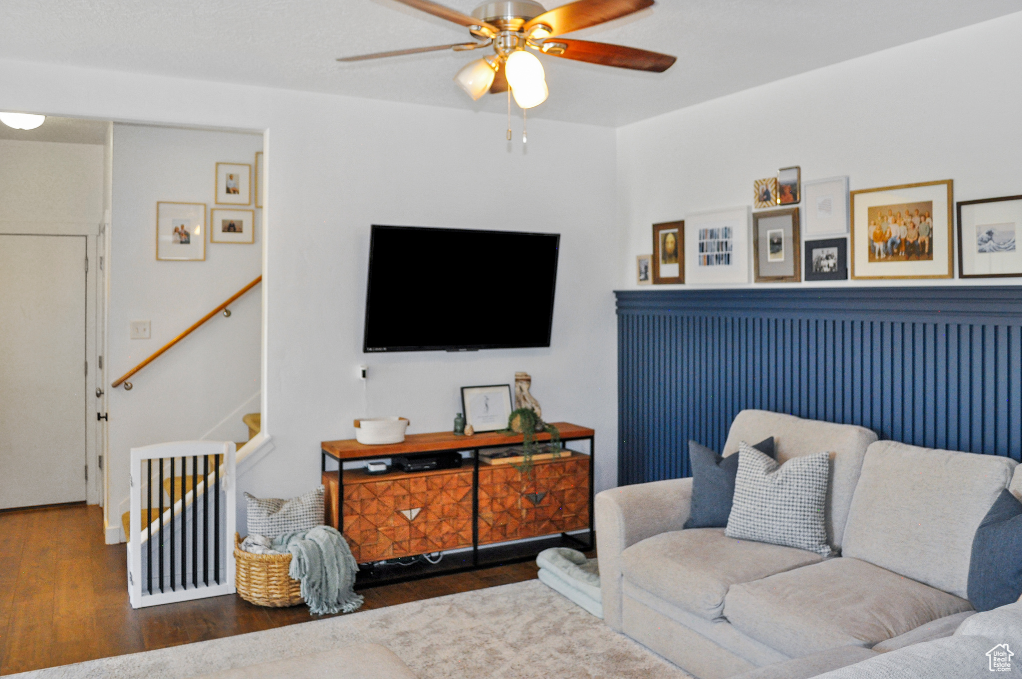 Living room with ceiling fan and dark hardwood / wood-style floors