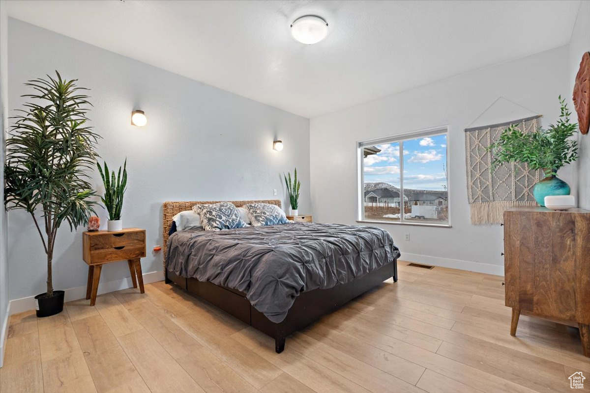 Bedroom with light hardwood / wood-style flooring