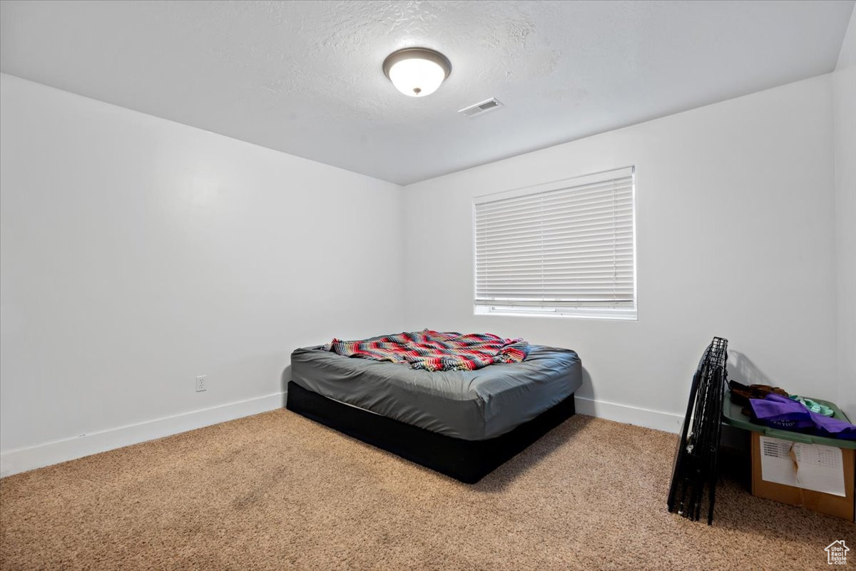 Carpeted bedroom with a textured ceiling