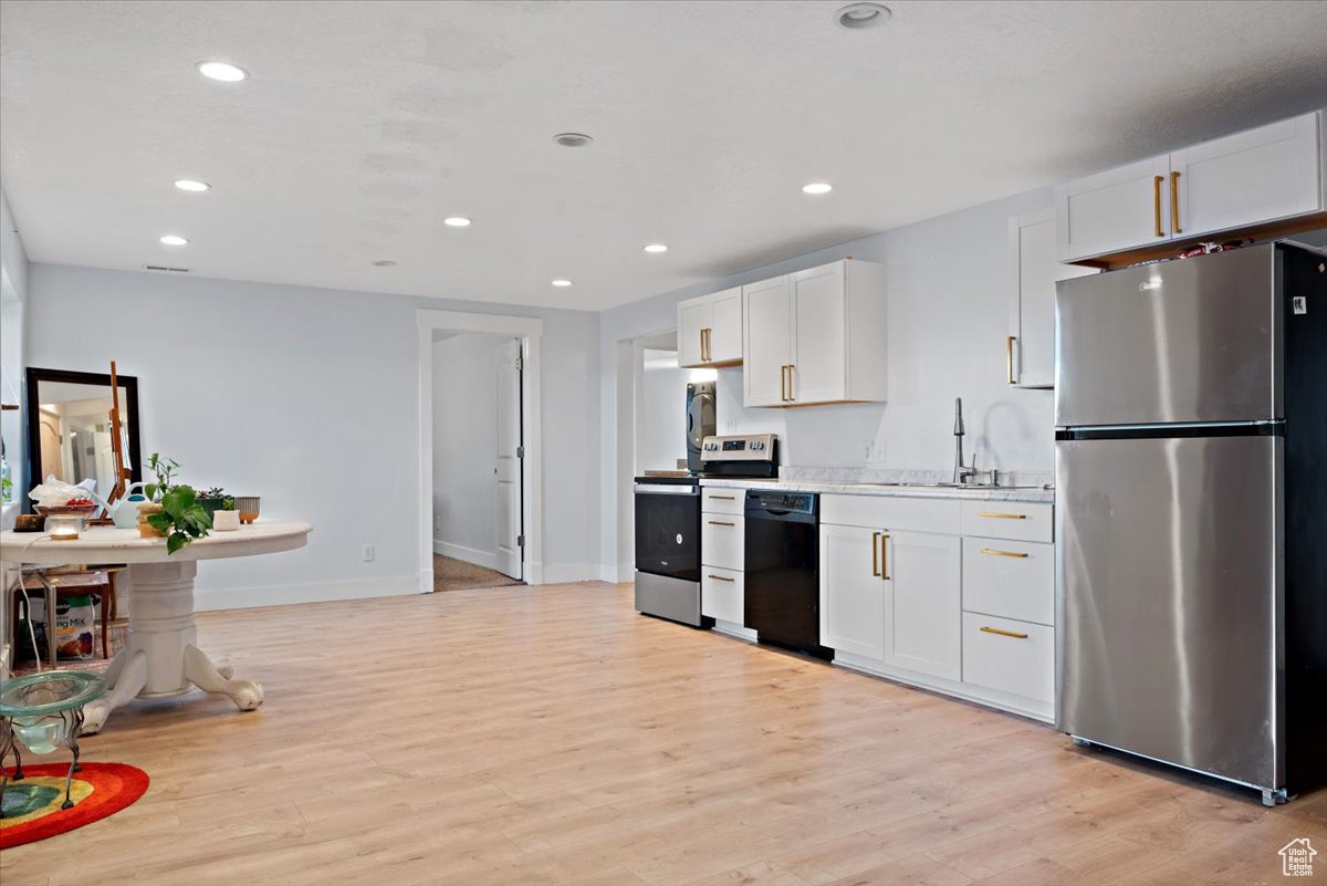 Kitchen featuring white cabinets, stainless steel appliances, light hardwood / wood-style flooring, and sink