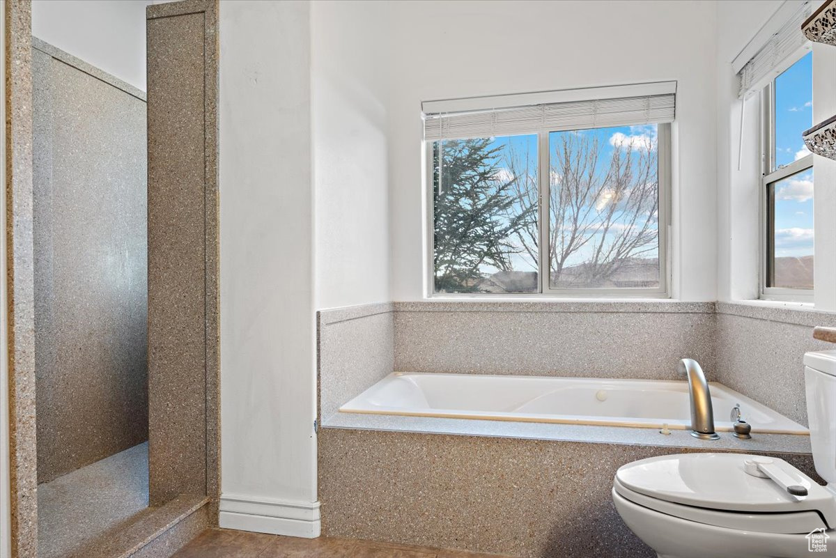 Bathroom featuring toilet, tile patterned floors, separate shower and tub, and a bidet