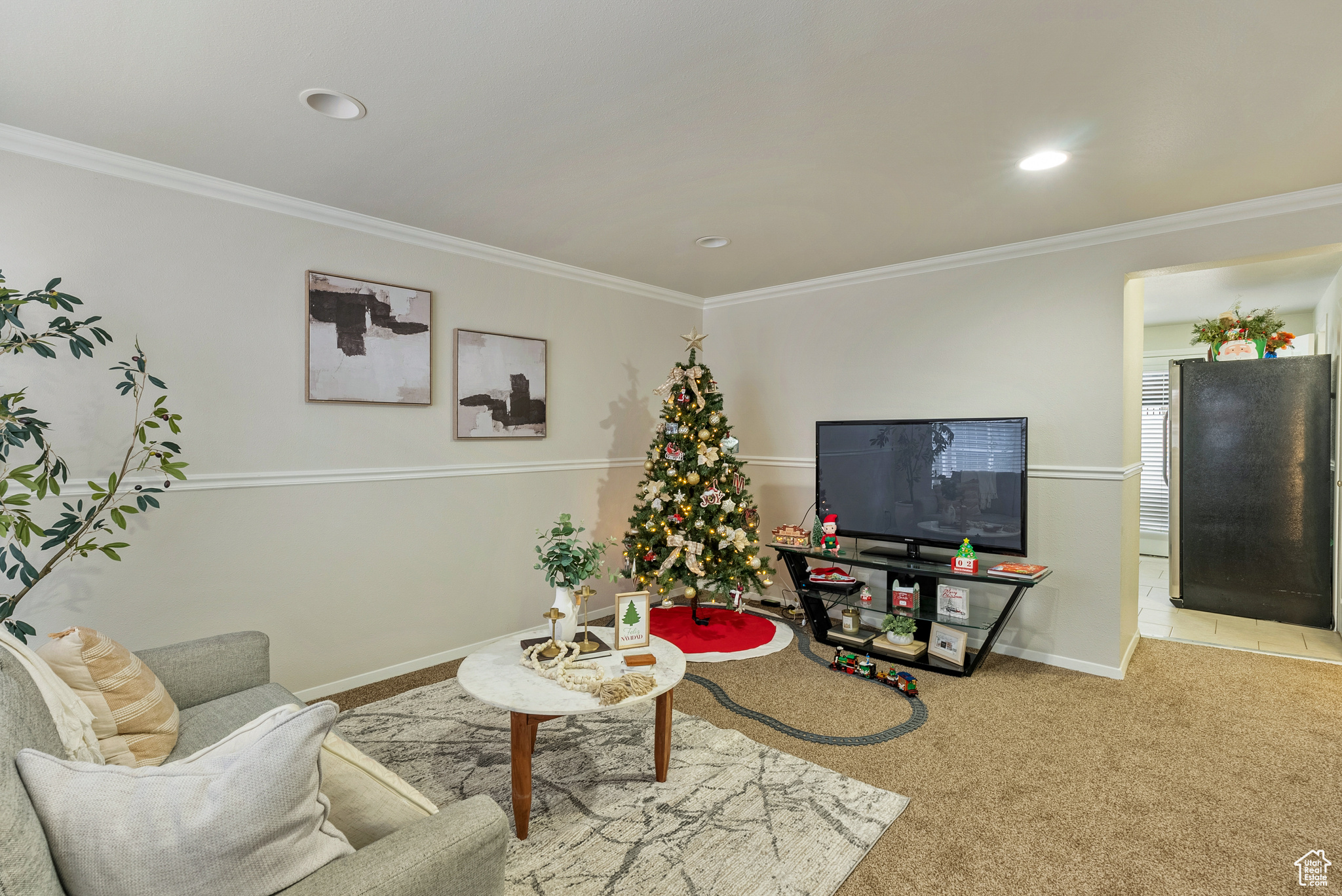 Carpeted living room featuring crown molding