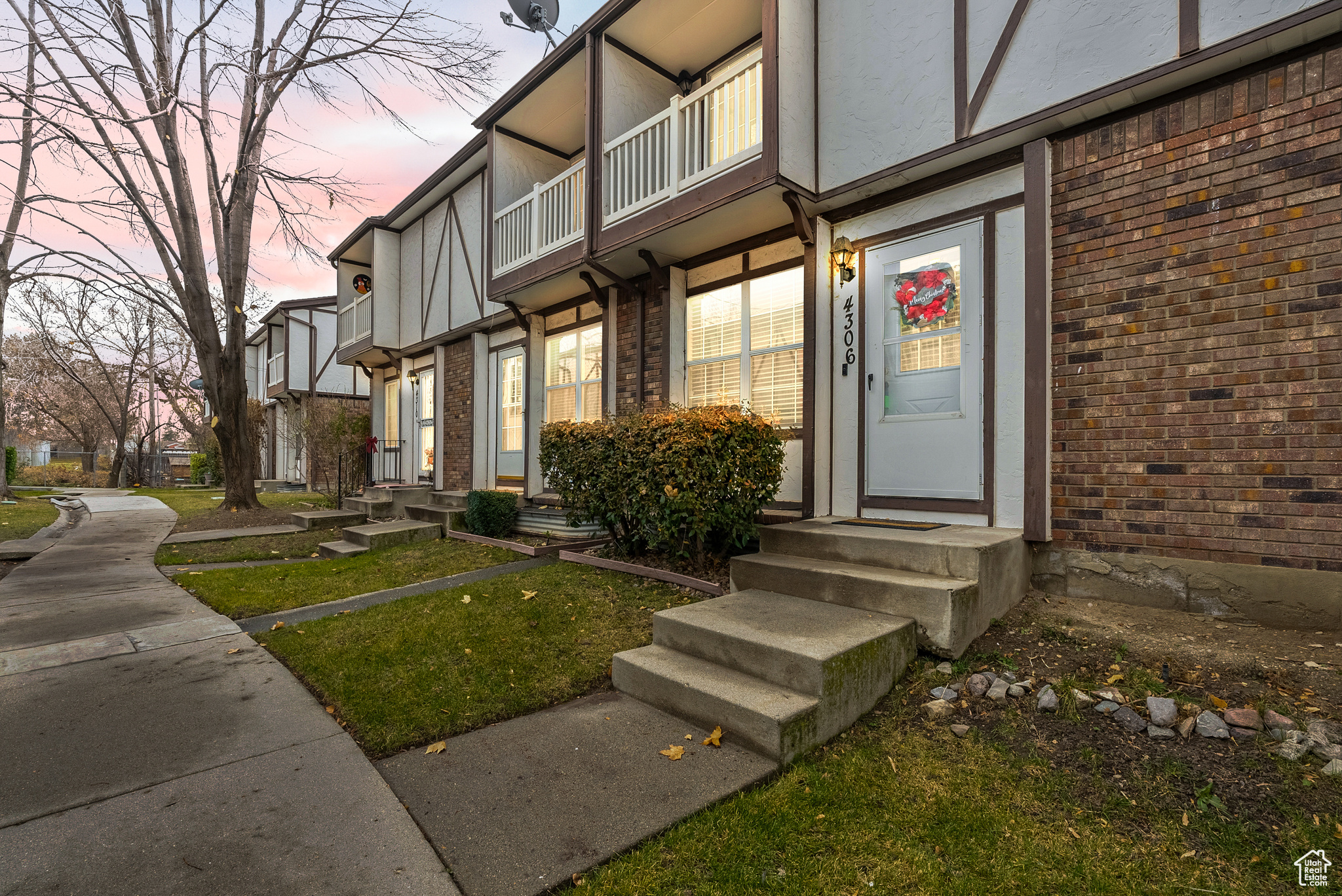 Exterior entry at dusk with a balcony