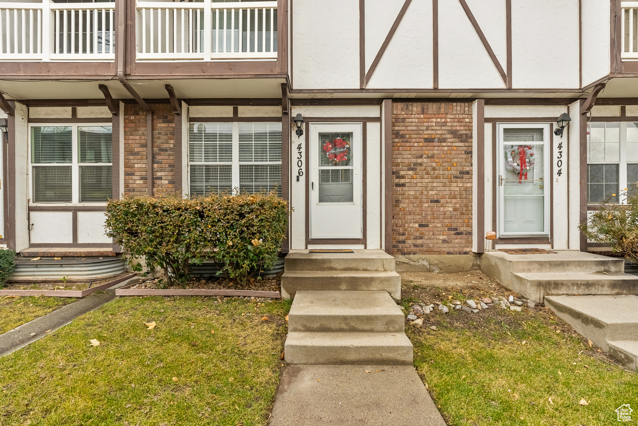 Property entrance with a yard and a balcony