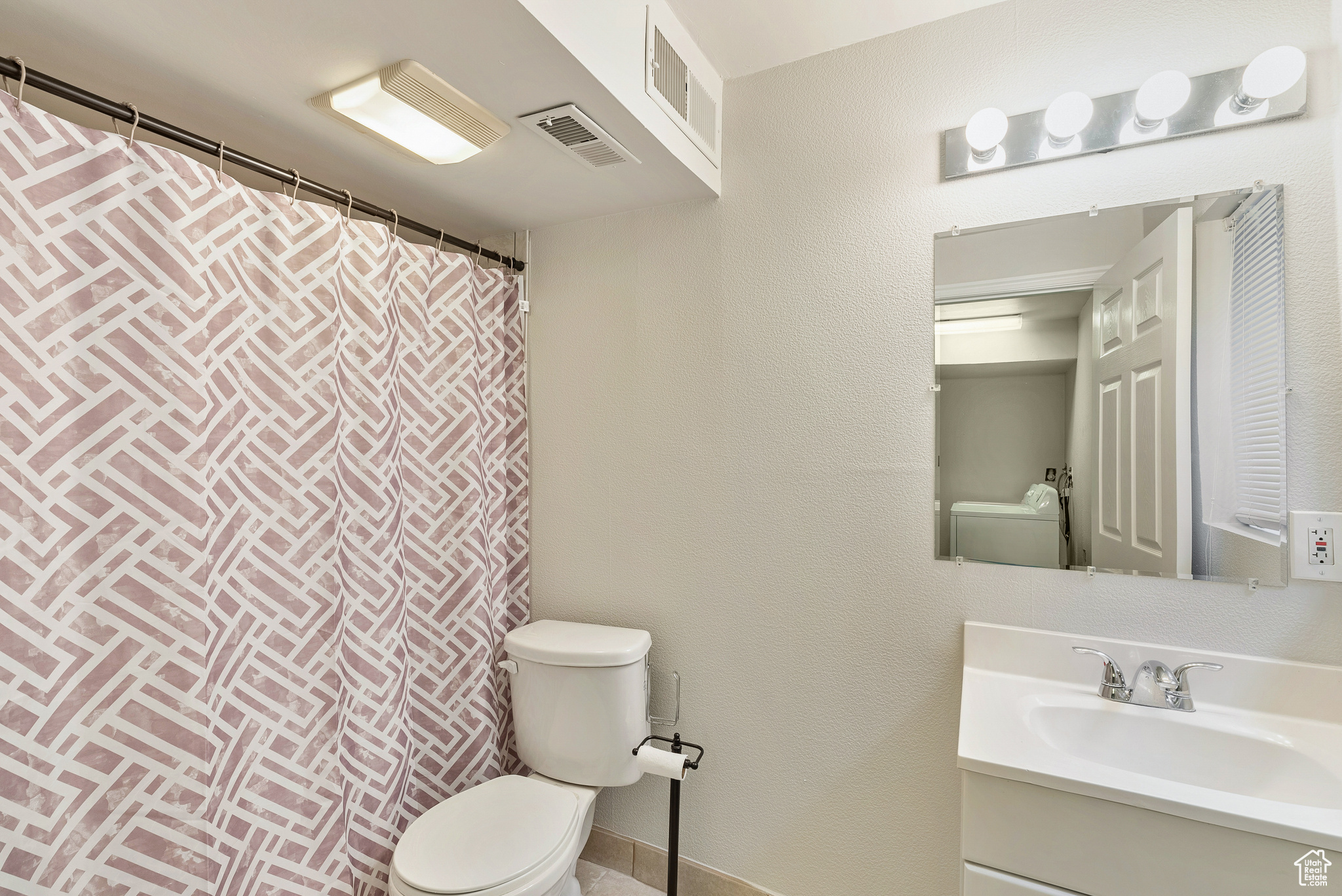 Bathroom featuring vanity, toilet, and walk in shower