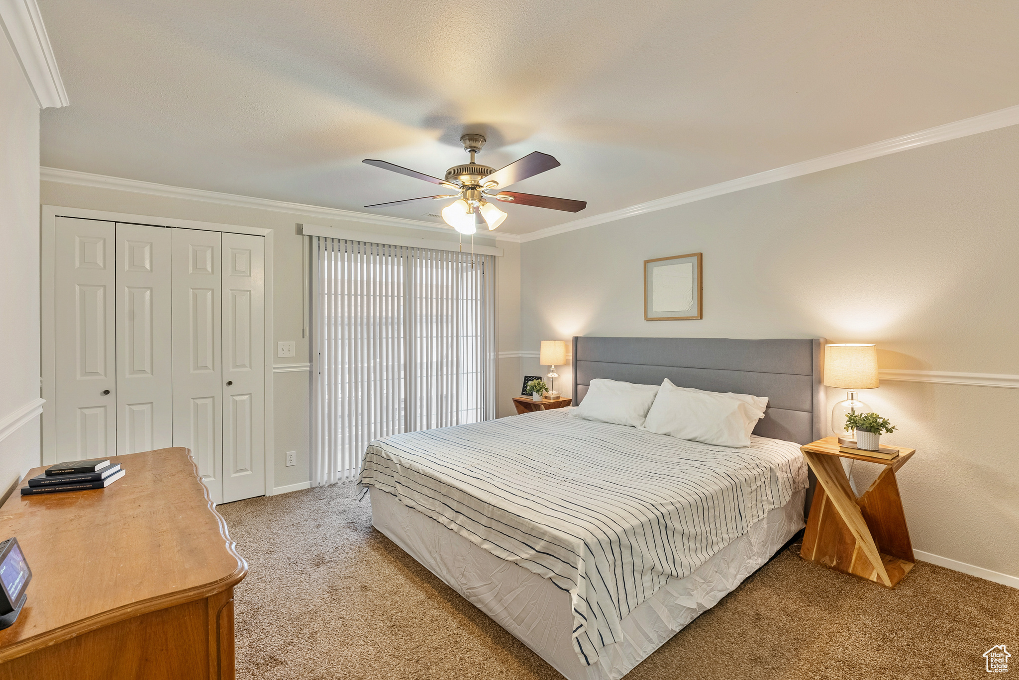 Bedroom featuring a closet, ceiling fan, crown molding, and light colored carpet