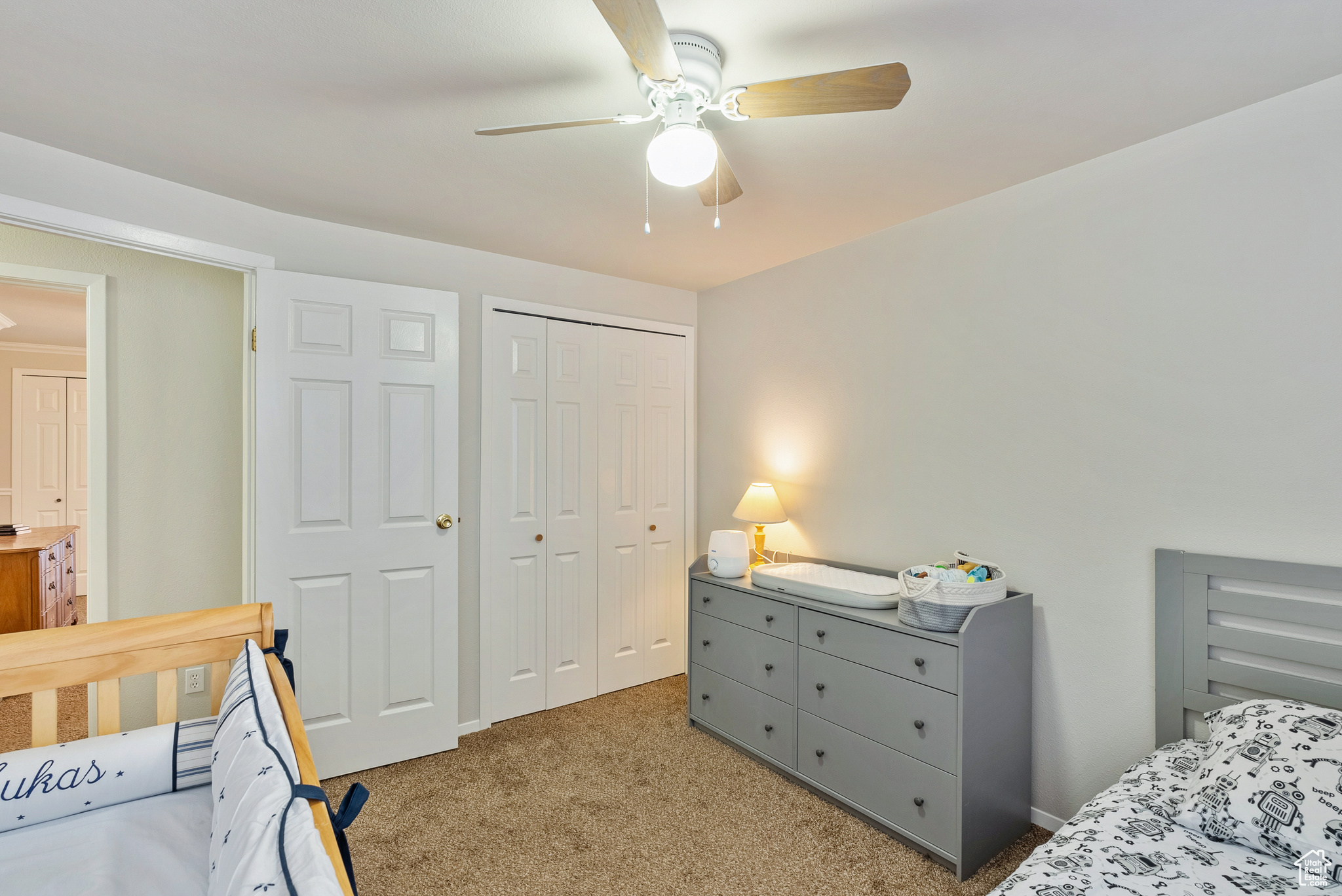 Bedroom with ceiling fan, a closet, and carpet floors