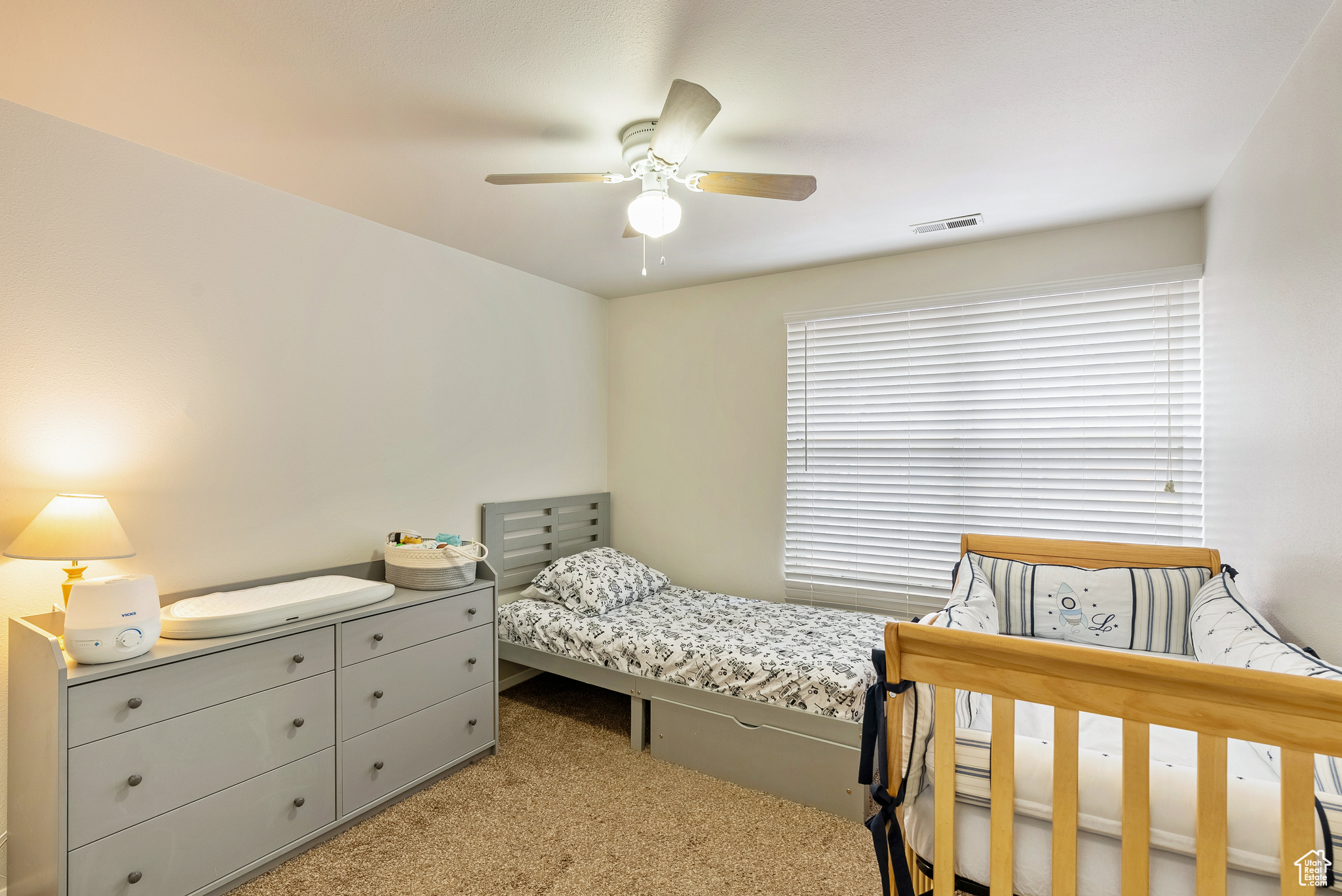 Bedroom with ceiling fan and light colored carpet