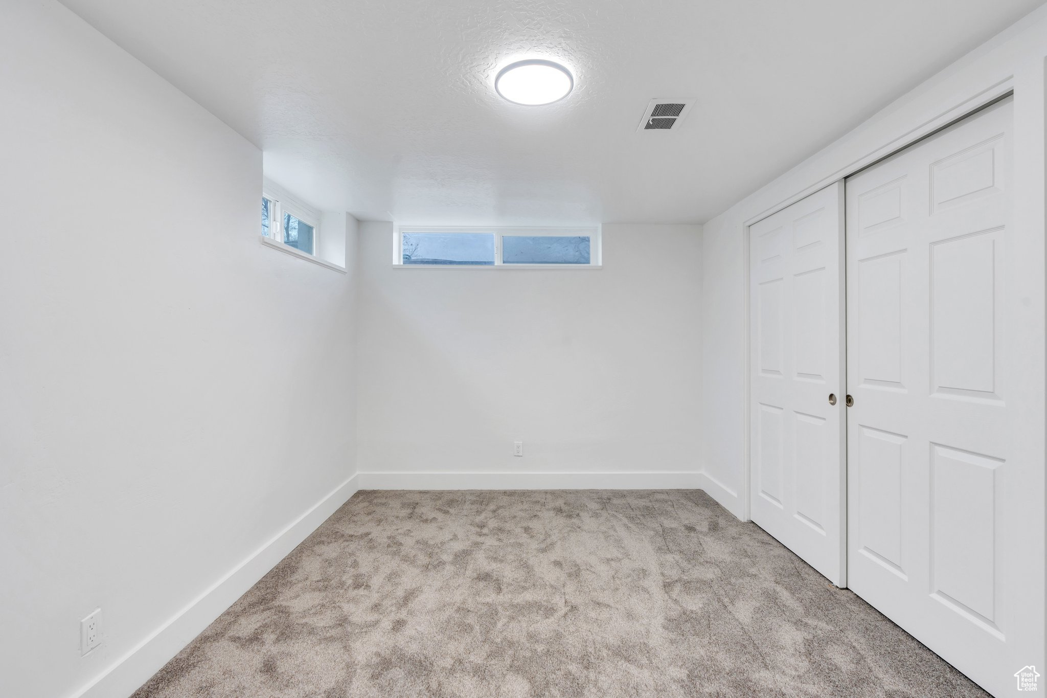 Basement featuring light carpet