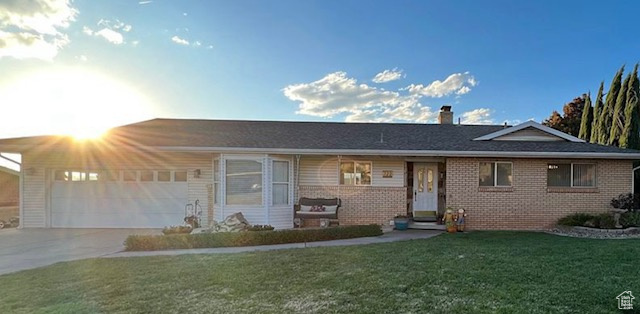 Single story home featuring a garage and a front lawn