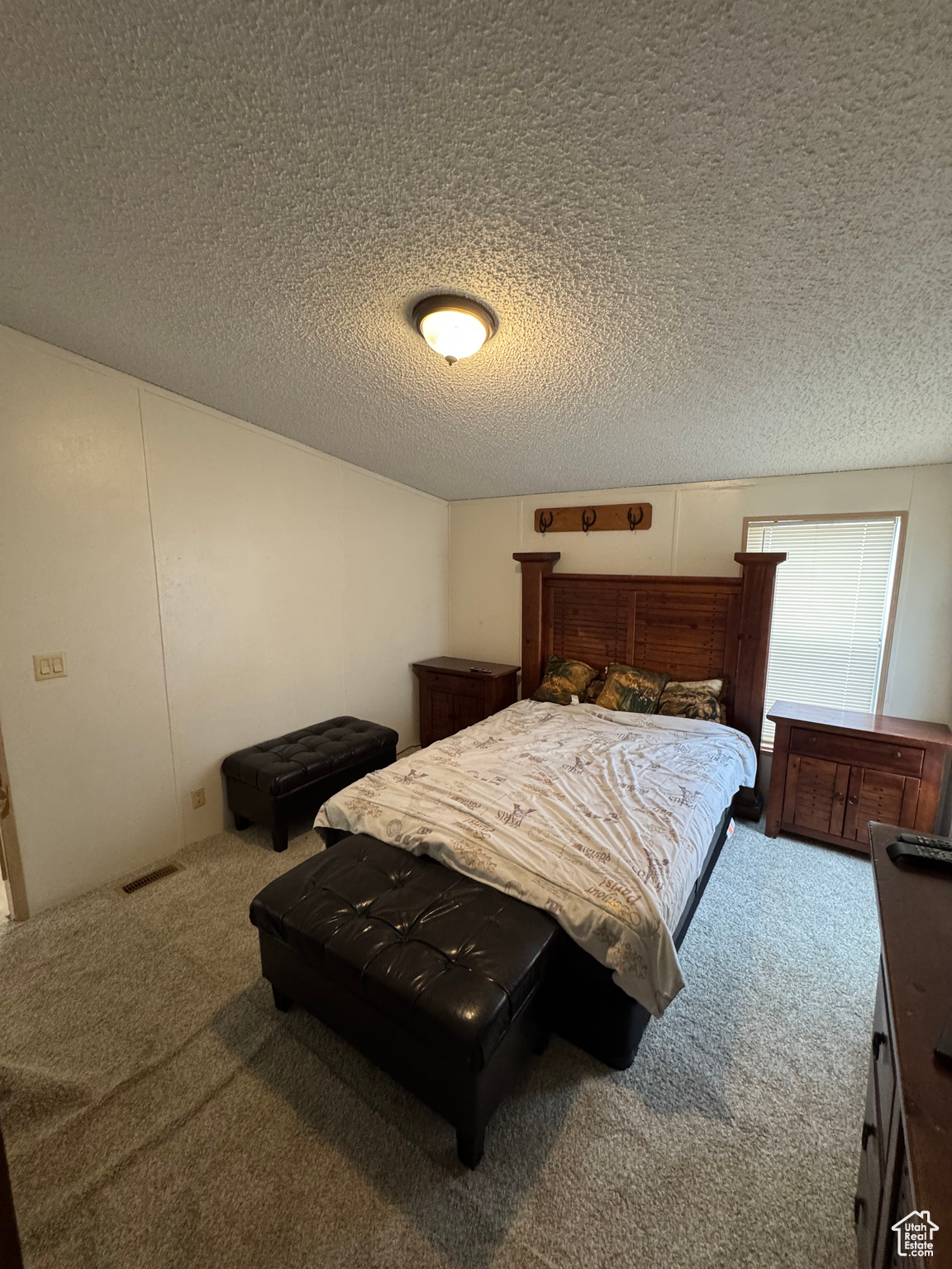 Carpeted bedroom featuring a textured ceiling