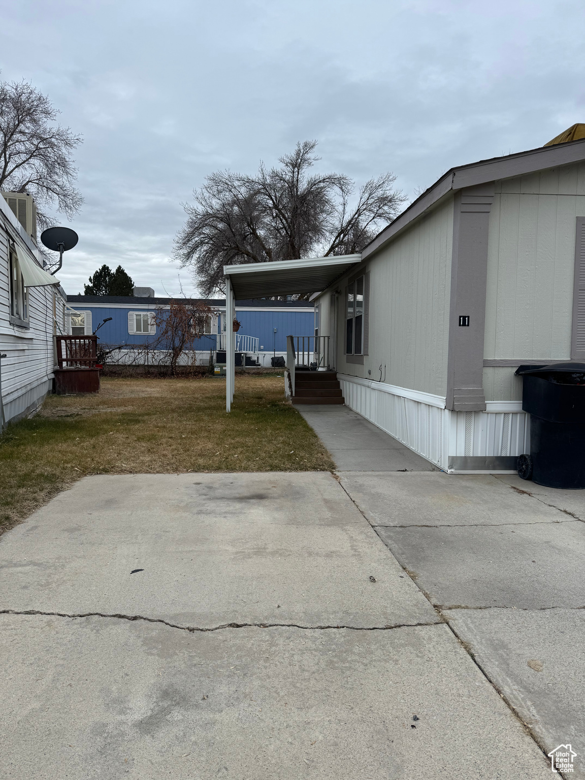 View of side of property with a yard and a carport