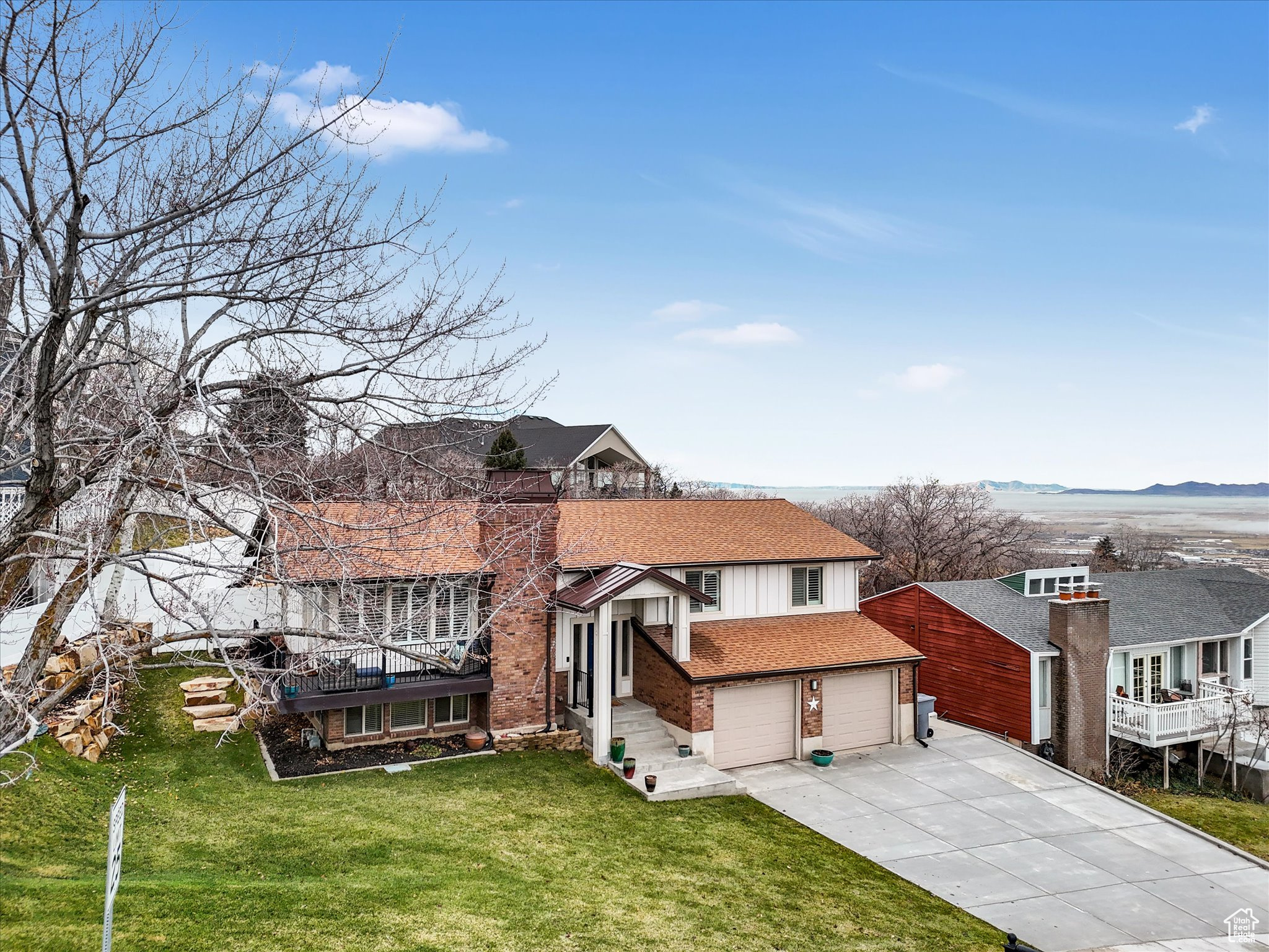 View of front of home with a front yard, a mountain view, and a garage