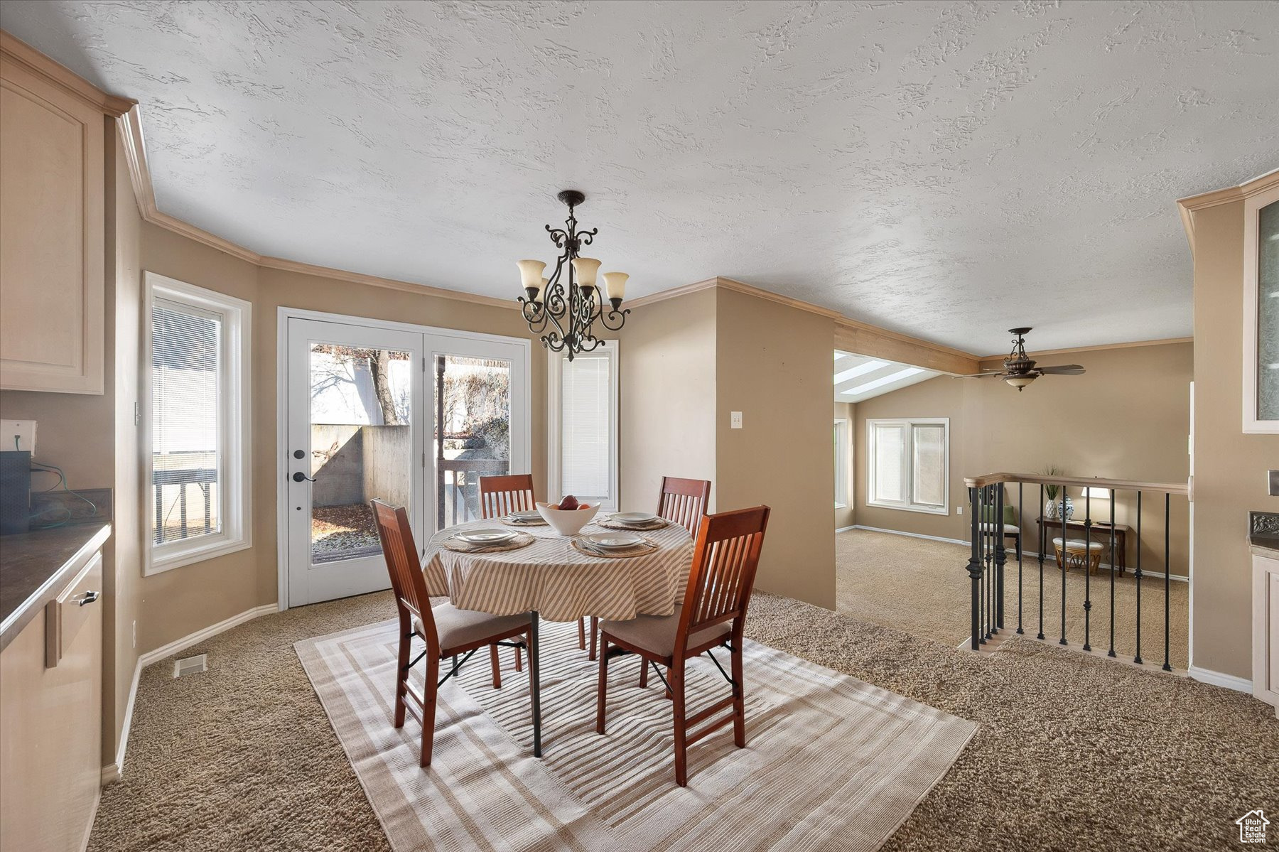 Semi-formal dining with French doors out to a covered deck & stairs down to the sunroom