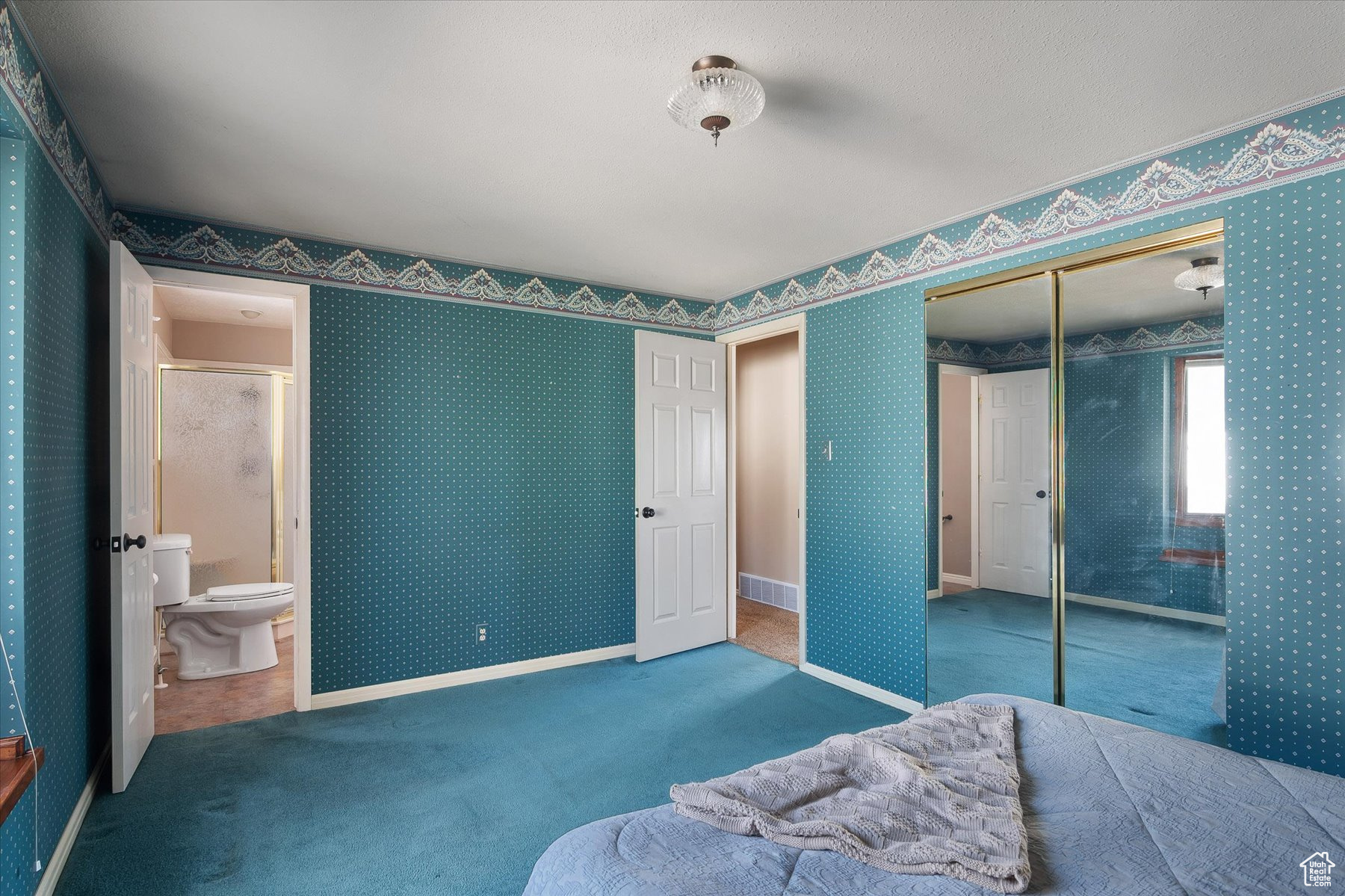 Primary bedroom closet & entrance to primary bath