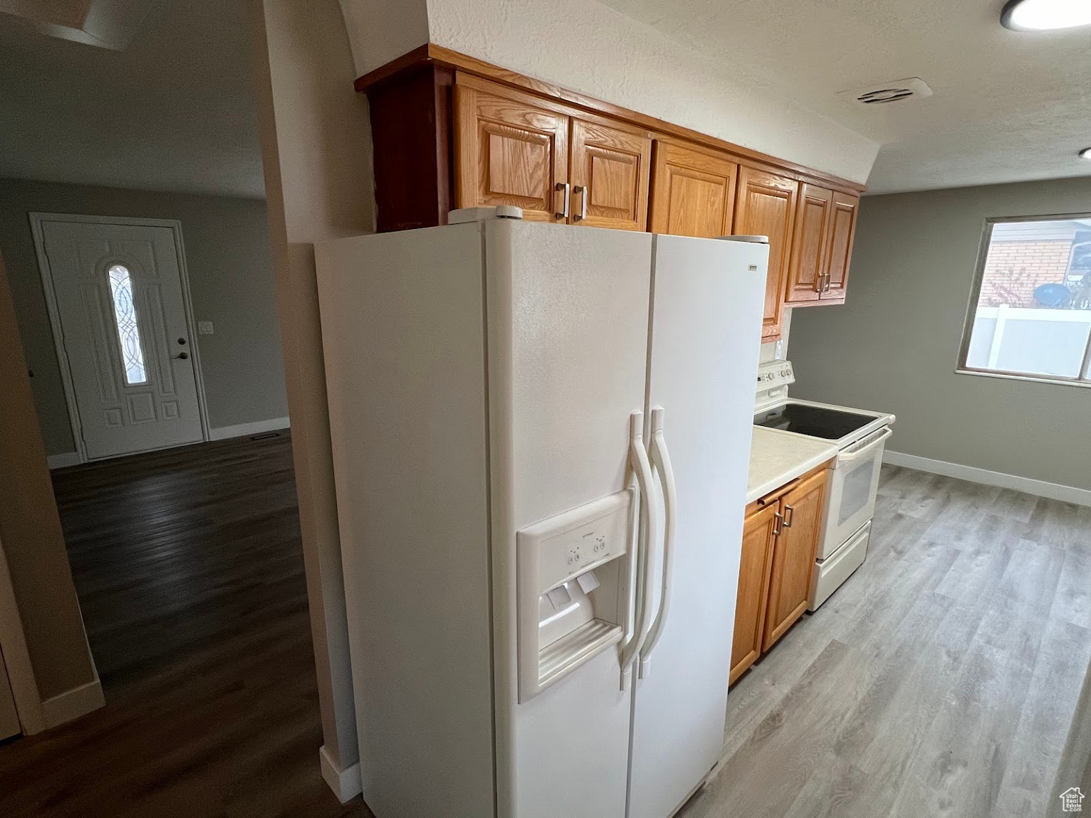 Kitchen with white appliances and light hardwood / wood-style flooring