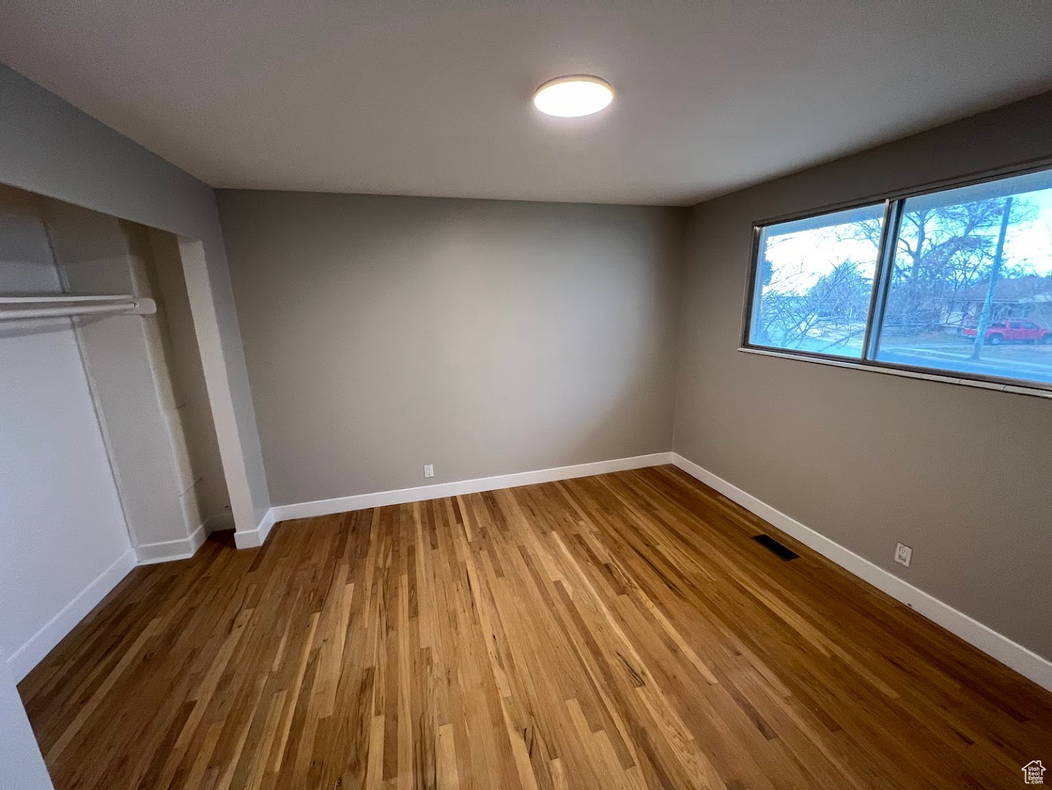 Unfurnished bedroom featuring wood-type flooring and a closet