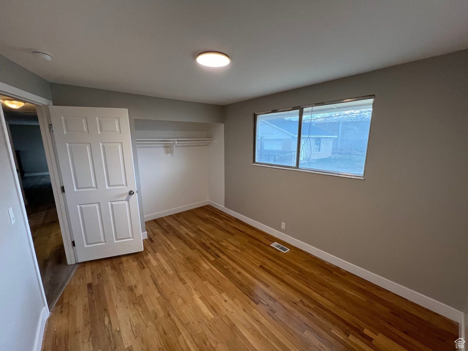 Unfurnished bedroom with light hardwood / wood-style flooring and a closet