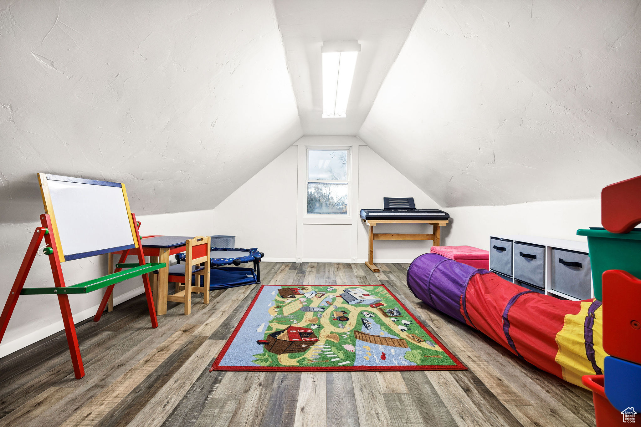 Recreation room featuring wood-type flooring and lofted ceiling