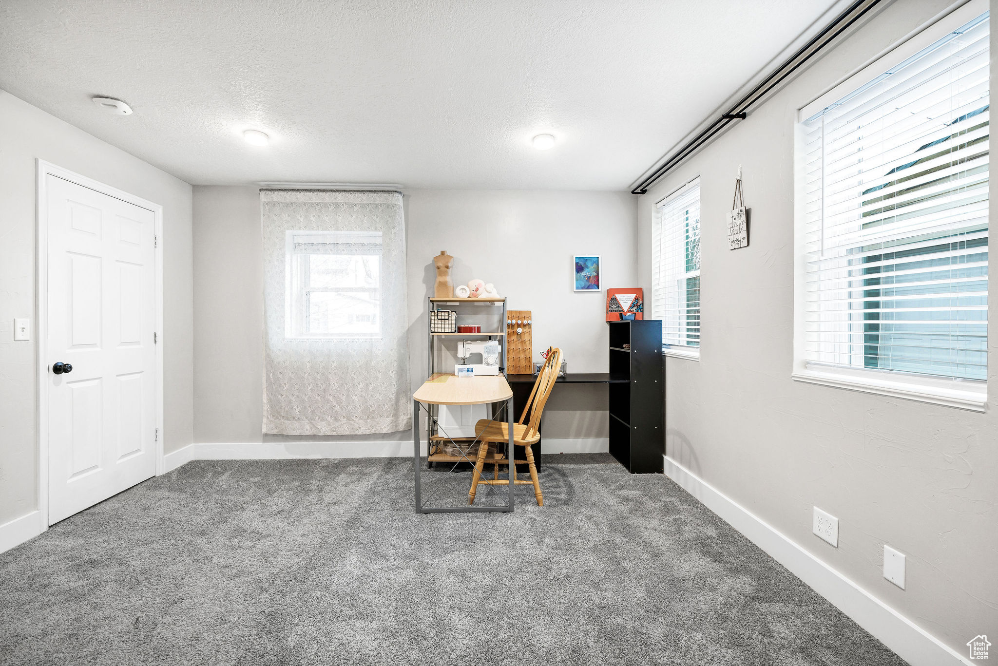 Home office with carpet floors and a textured ceiling