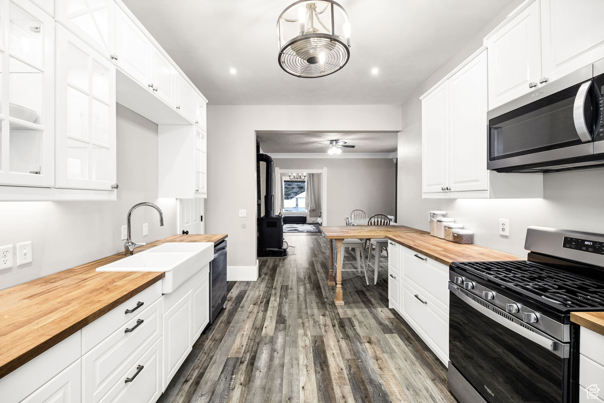 Kitchen with white cabinets, sink, stainless steel appliances, and wooden counters