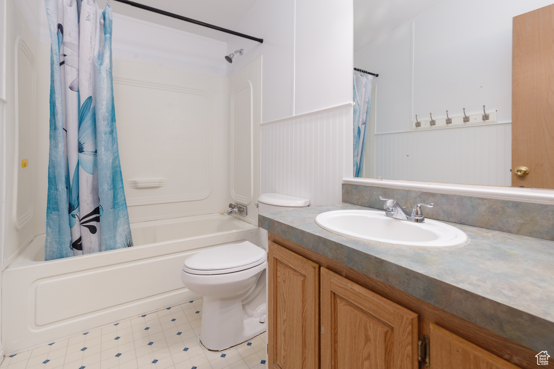 Full bathroom with vanity, shower / bath combination with curtain, and toilet