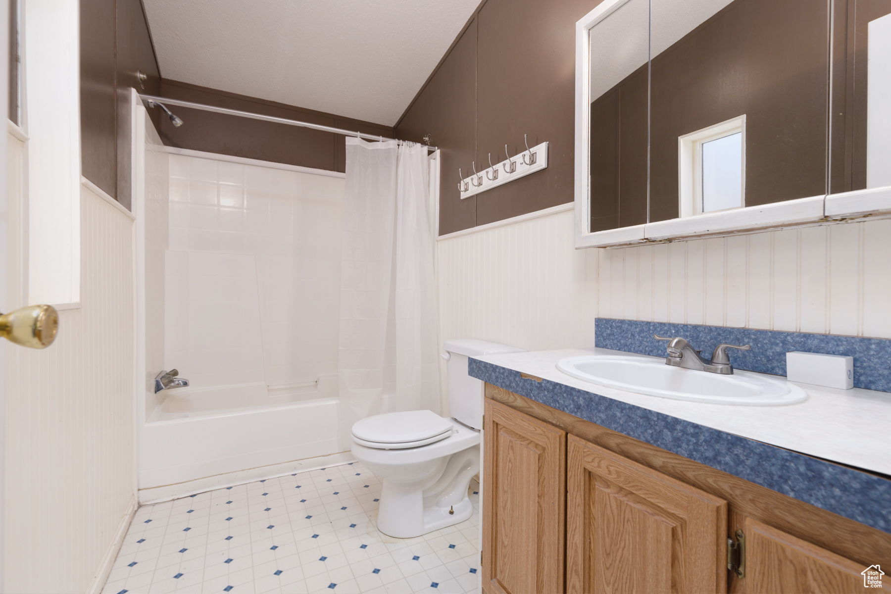 Full bathroom featuring shower / tub combo, vanity, and toilet