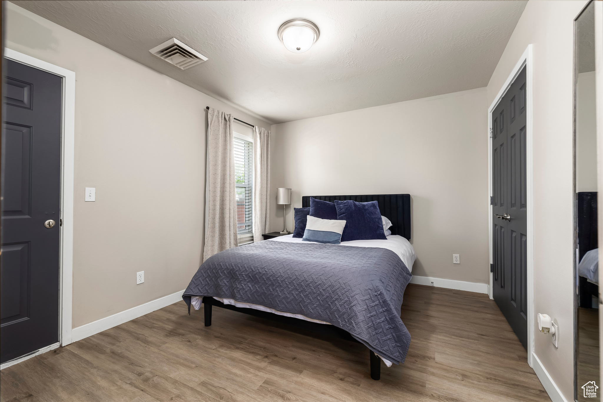 Bedroom featuring hardwood / wood-style floors and a textured ceiling