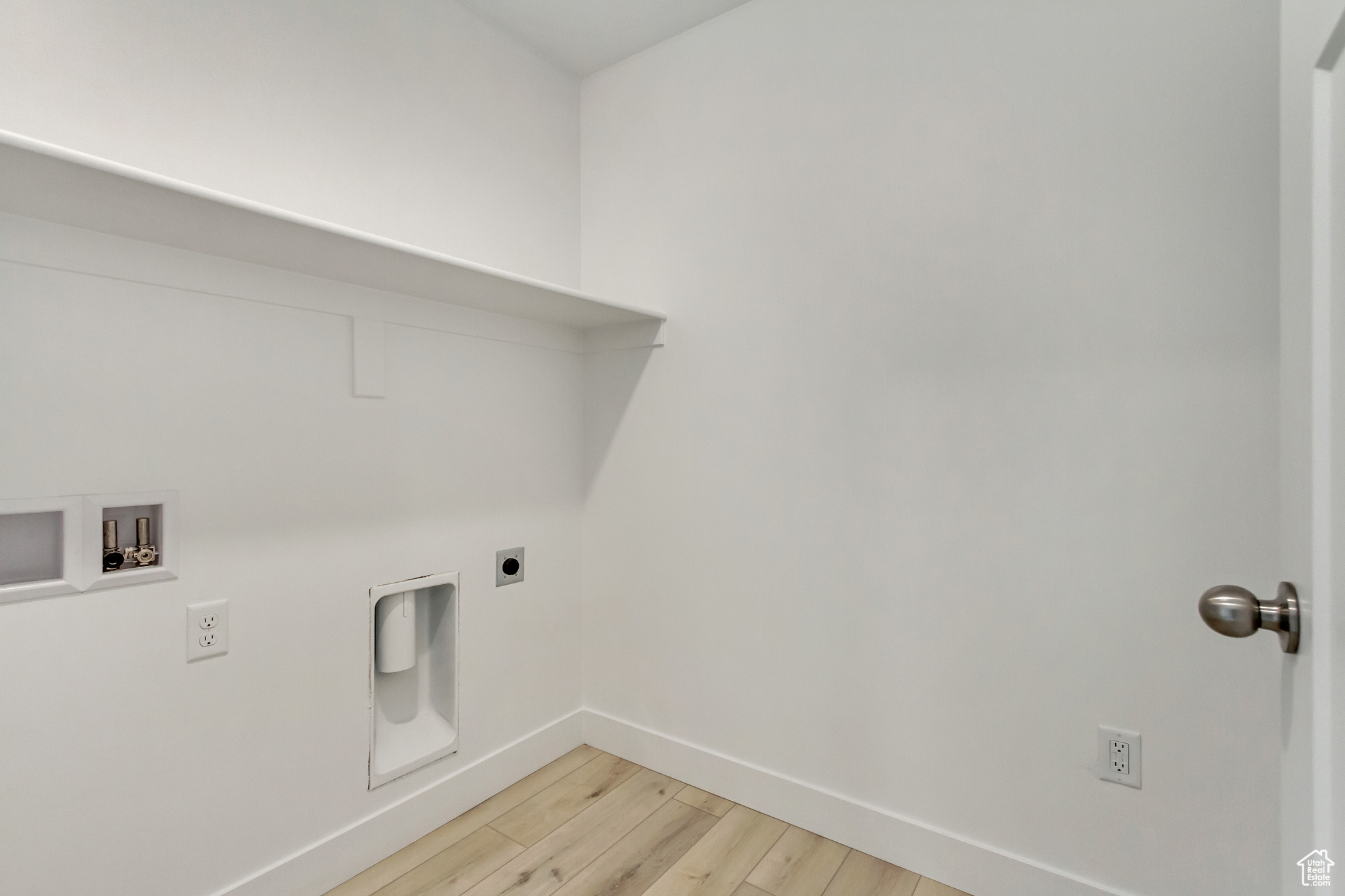 Clothes washing area with hookup for an electric dryer, hardwood / wood-style flooring, and washer hookup