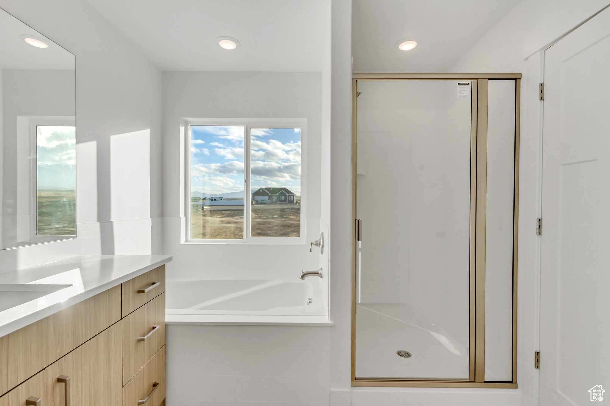 Bathroom featuring vanity and independent shower and bath